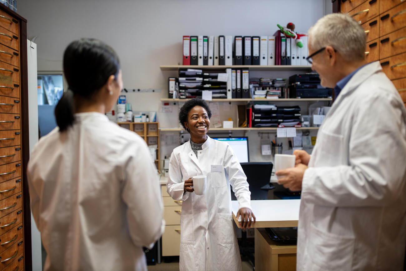 Three pharmacists having a coffee break at pharmacy