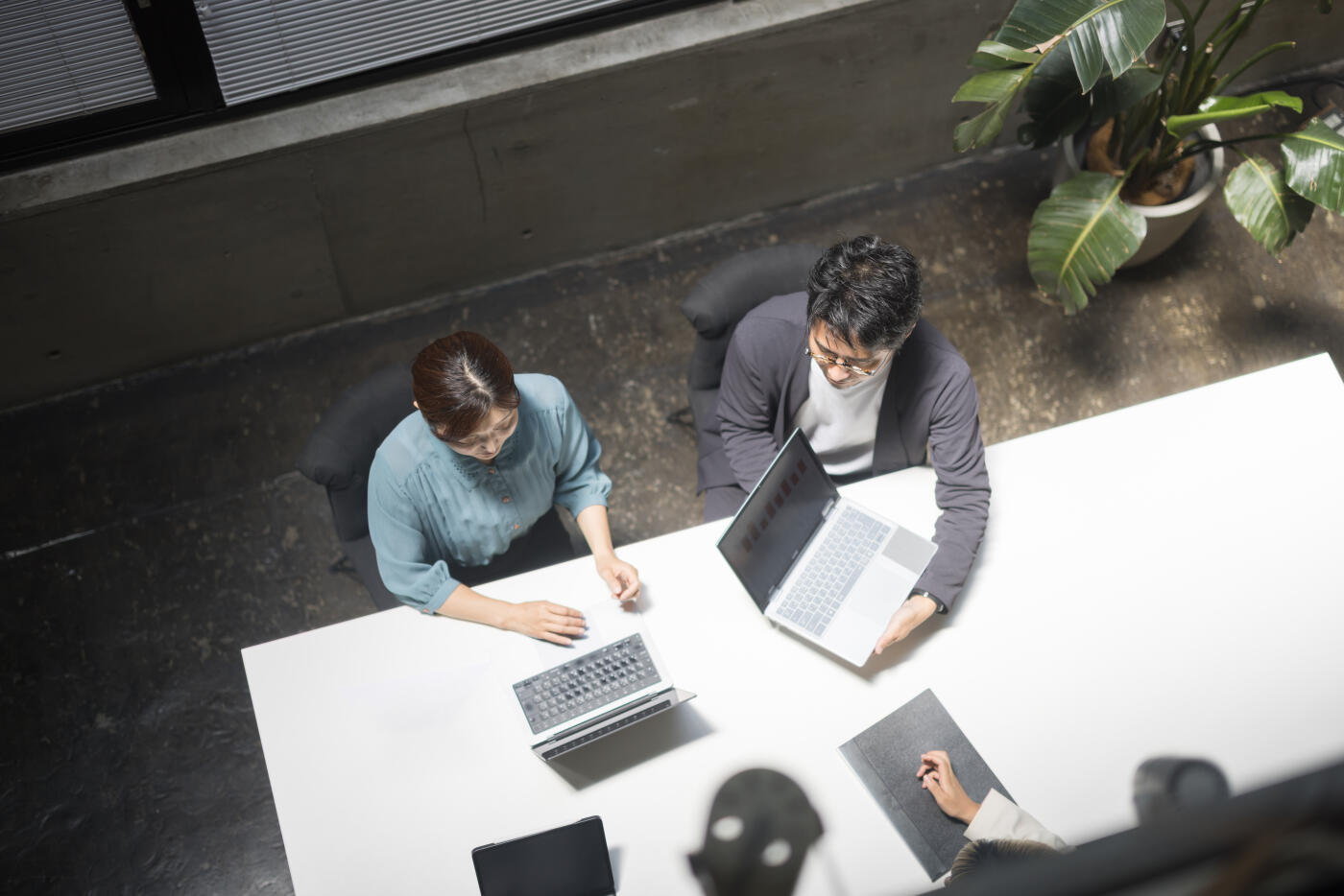 A bird's-eye view photo of business people having a meeting in a conference room.