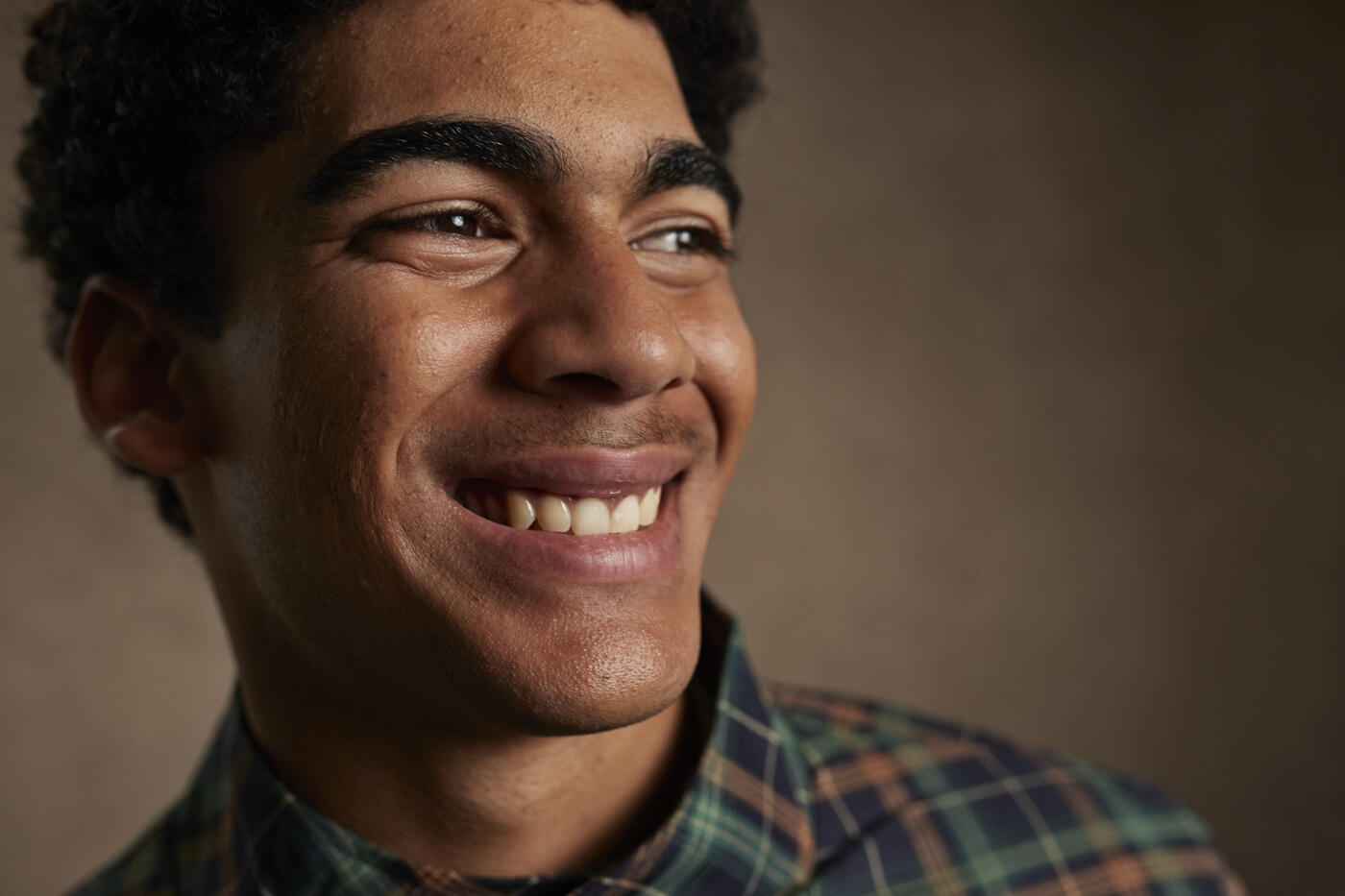 Headshot of smiling young man looking away