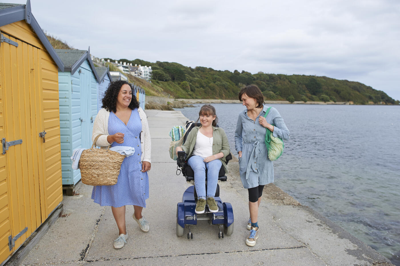 A group of friends smiling together whilst by the sea
