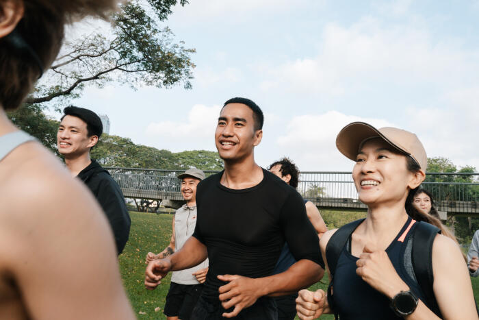 Group of runners jogging together through the park, participating in their regular club activity