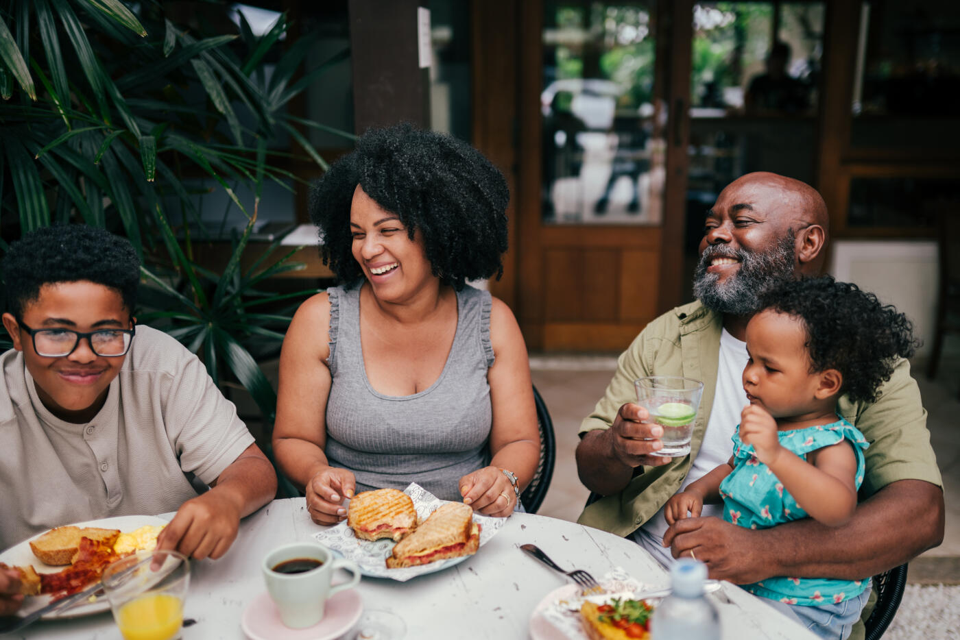 Family with kids having a lunch together in a restaurant, while their vacations