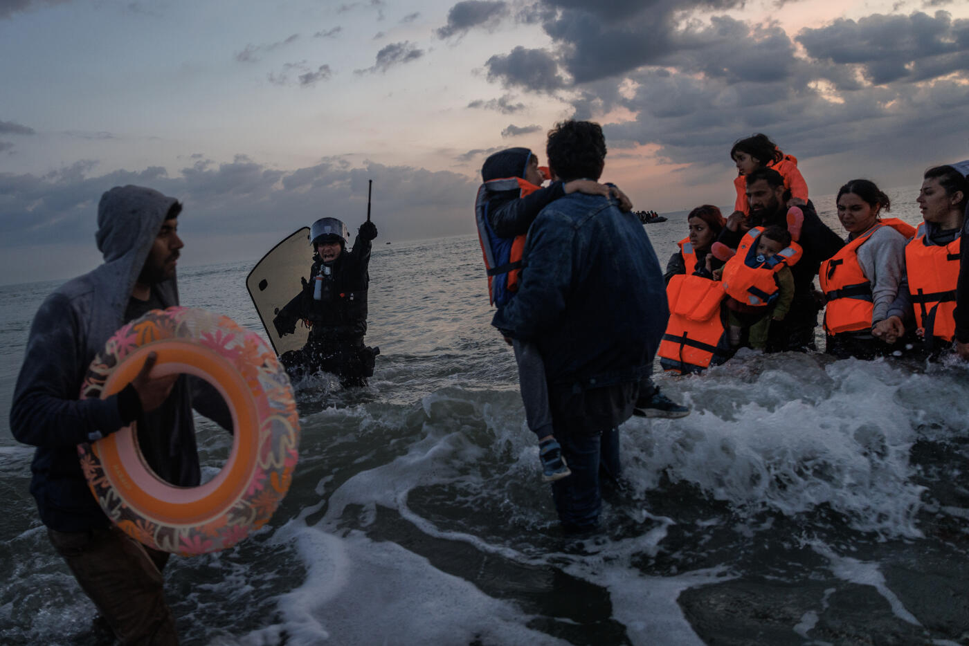 GRAVELINES, FRANCE - JUNE 13: French Police enter the water to try and stop migrants boarding small boats that had come to collect them from further down the coastline on June 13, 2025 in Gravelines, France. Police used tear gas and pepper spray to try and disperse hundreds of migrants aiming to board several boats but were ultimately overwhelmed by the sheer numbers of people. A record number of migrants have left the northern french coastline and arrived in the UK so far this year, with figures surpassing the 15,000 mark. The UK government has vowed to crackdown on people smugglers and illegal migration, with Chancellor Rachel Reeves announcing as part of the government's spending review on Wednesday that the Border Security Command would be funded up to £280m more per year by the end of the review period in 2028-29. (Photo by Dan Kitwood/Getty Images)