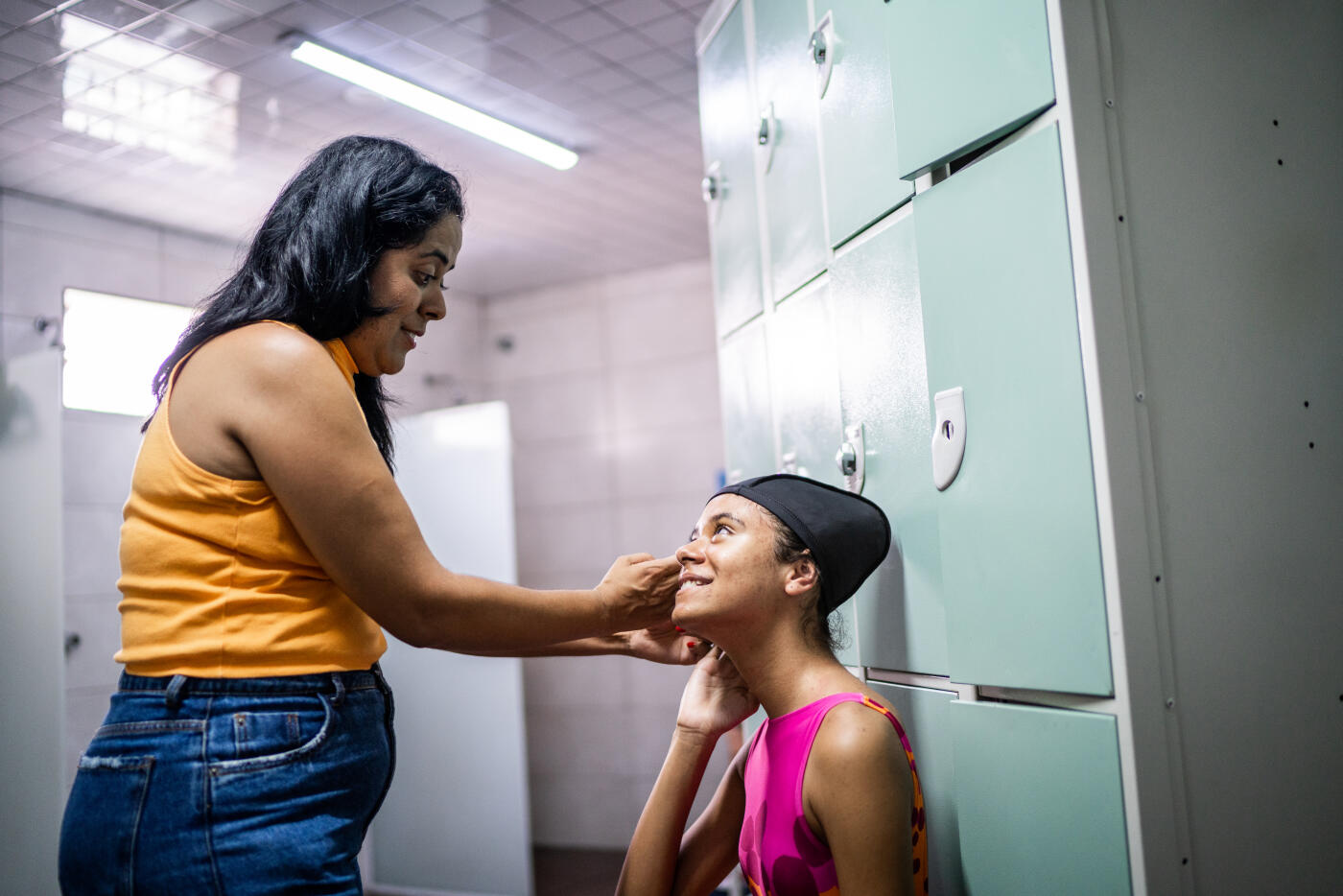 Mother helping daughter in the swimming club locker room