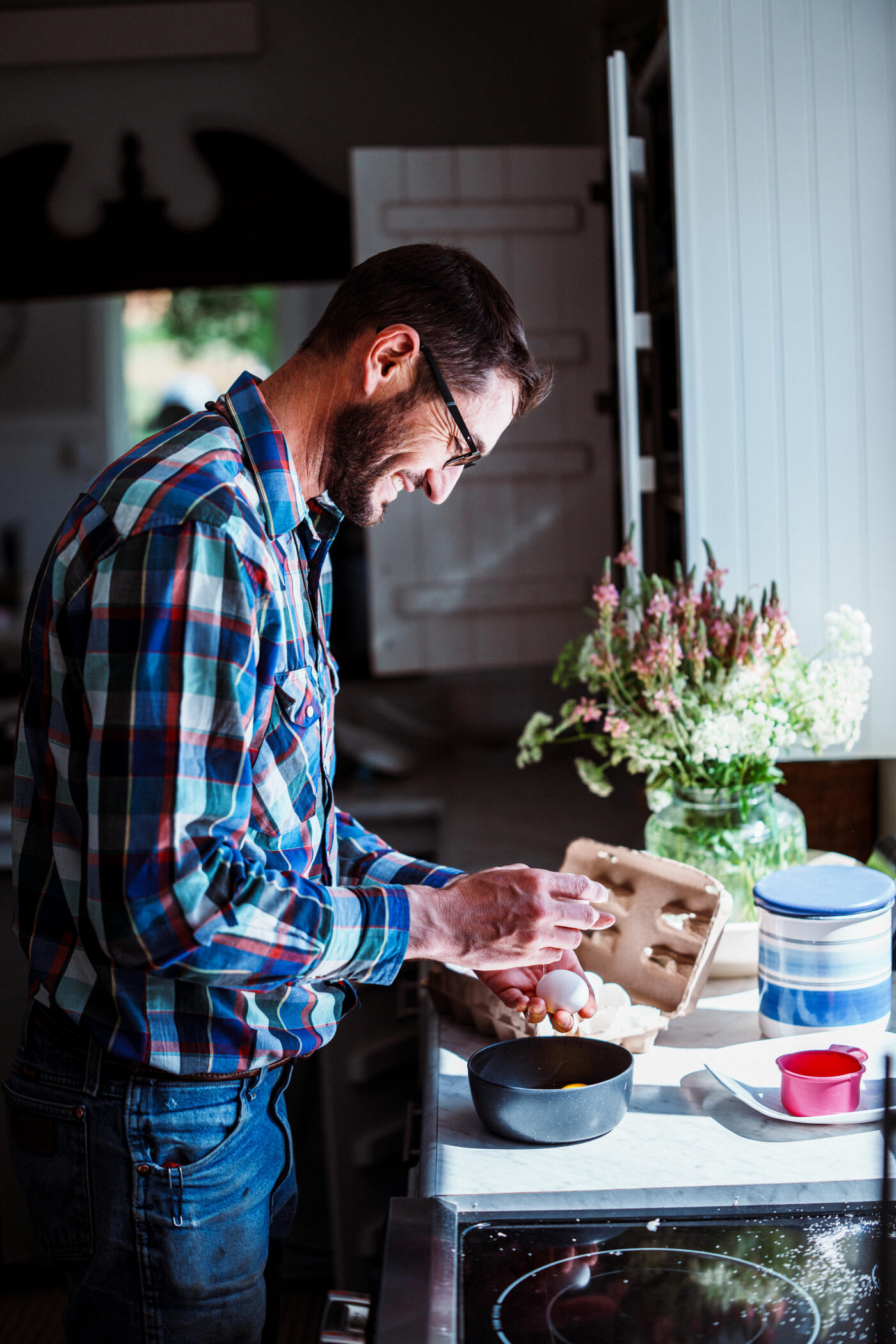 A rancher stands in his bright farmhouse kitchen and prepares scrambled eggs for breakfast.