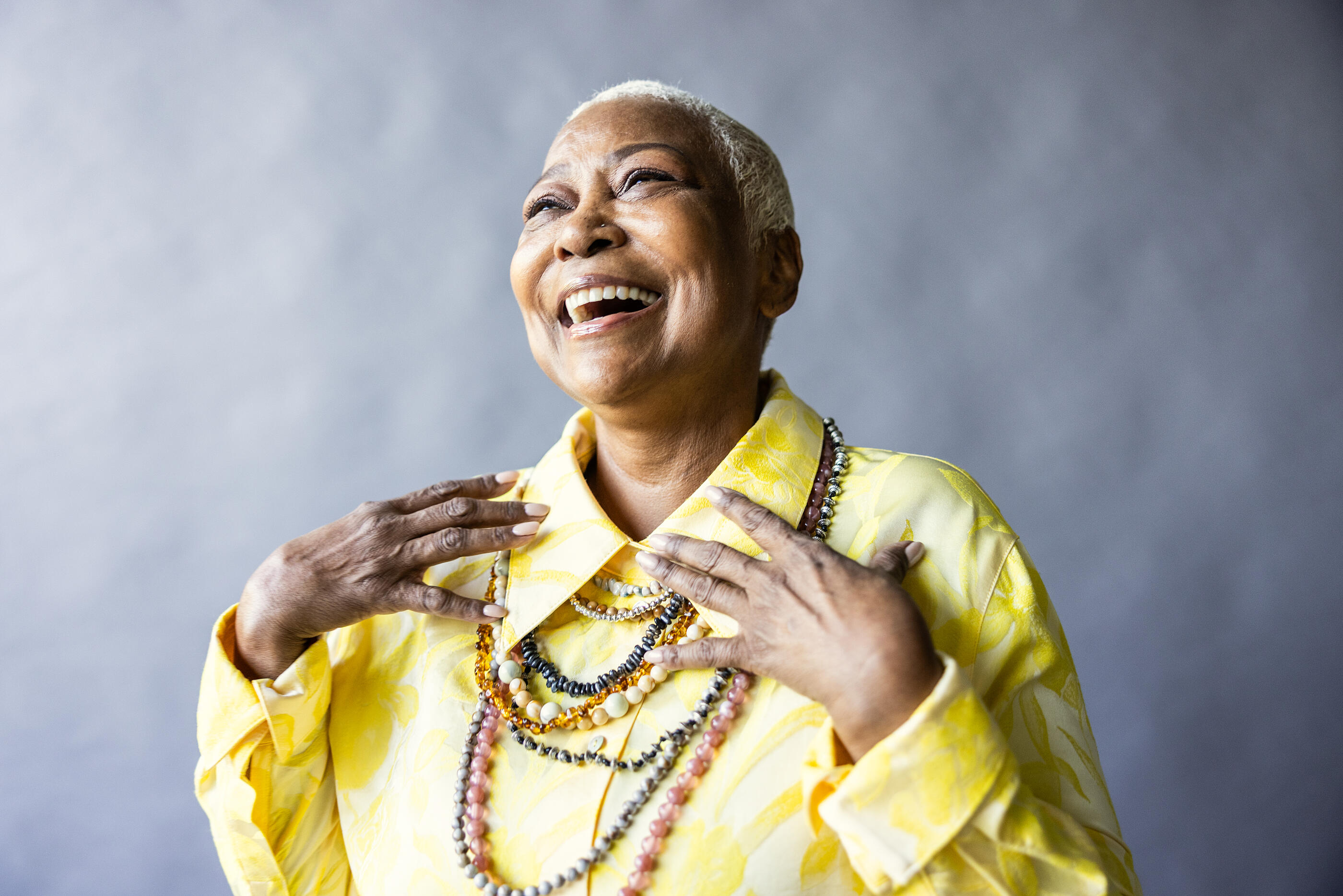 Portrait of beautiful senior woman with short hair on gray background