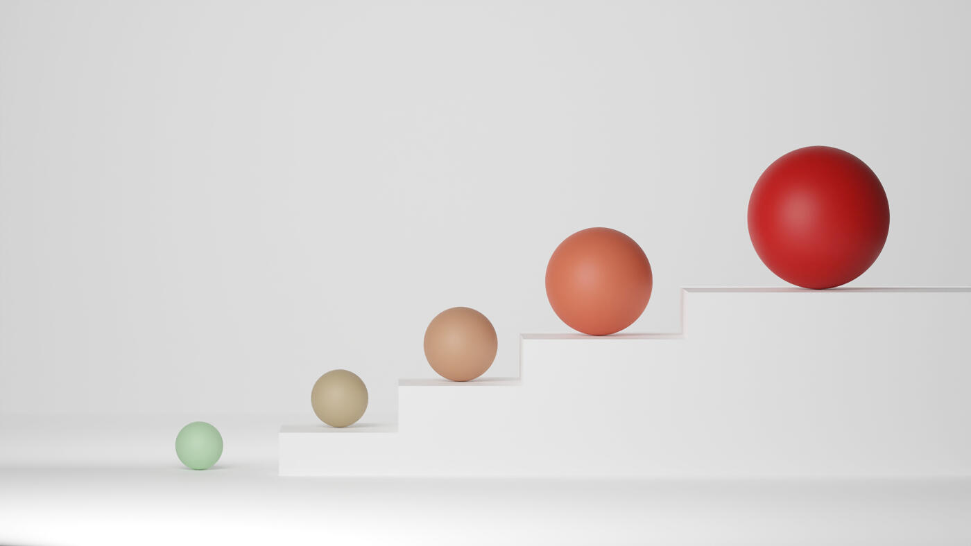 Four spheres of increasing size going up a staircase, representing growth, progress and success