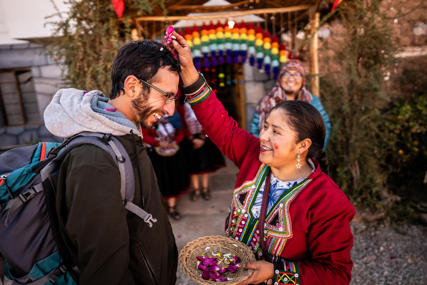 Chinchero indigenous women greeting tourist with flower petals, in Chinchero District