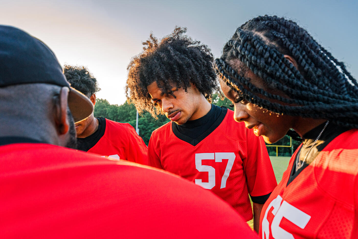Youth Flag Football Sports Team Bonding and Practicing Together at Sunset in Summer