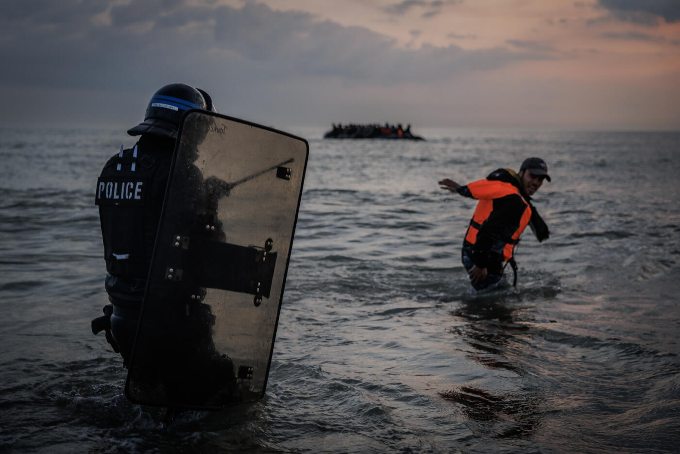 GRAVELINES, FRANCE - JUNE 13: French Police enter the water to try and stop migrants boarding small boats that had come to collect them from further down the coastline on June 13, 2025 in Gravelines, France. Police used tear gas and pepper spray to try and disperse hundreds of migrants aiming to board several boats but were ultimately overwhelmed by the sheer numbers of people. A record number of migrants have left the northern French coastline and arrived in the UK so far this year, with figures surpassing the 15,000 mark. The UK government has vowed to crackdown on people smugglers and illegal migration, with Chancellor Rachel Reeves announcing as part of the government's spending review on Wednesday that the Border Security Command would be funded up to £280m more per year by the end of the review period in 2028-29. (Photo by Dan Kitwood/Getty Images)