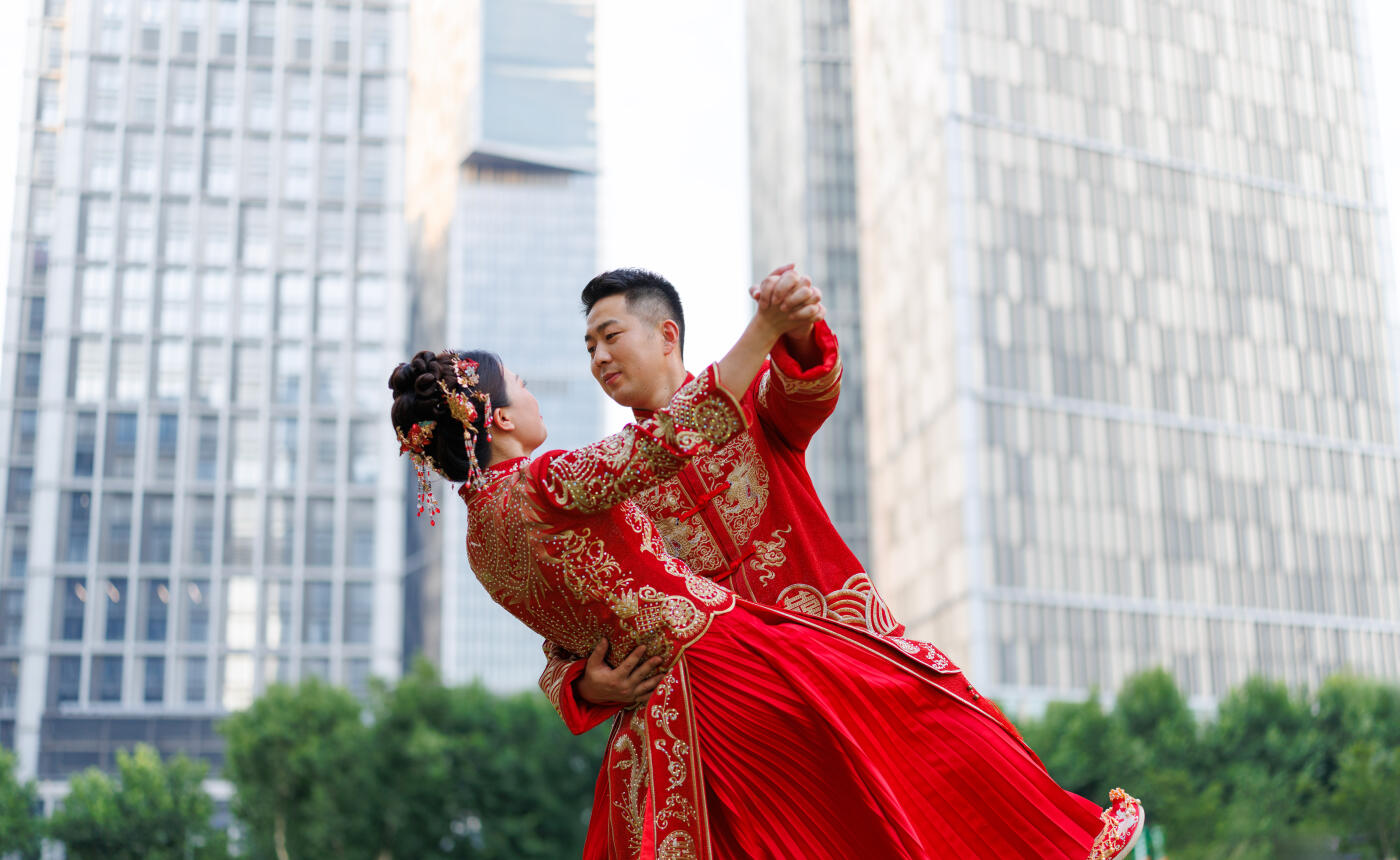 A Chinese newlywed couple in their 30s, wearing Hanfu costumes, hug each other in a modern city on their wedding day, traditional costumes and modern city concept