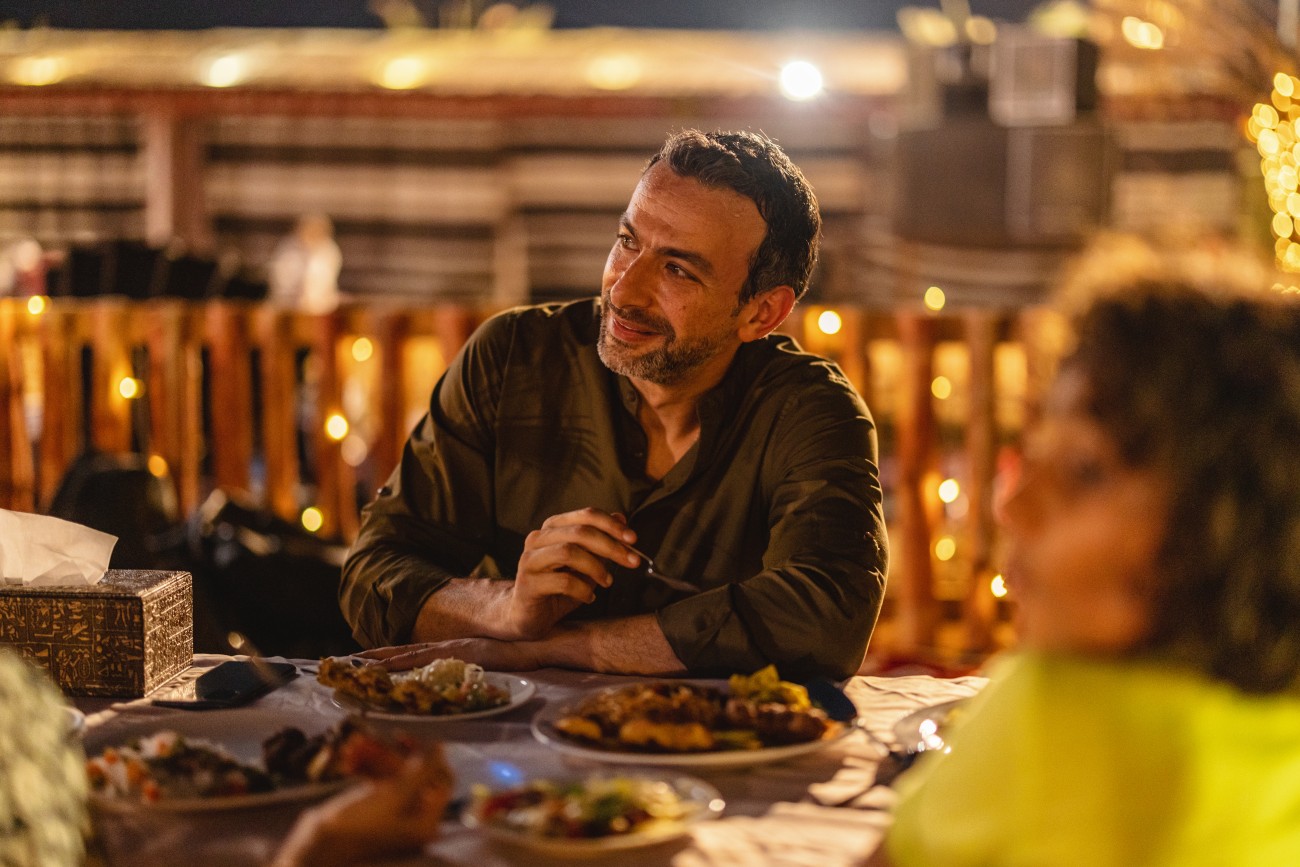 Focused shot of a Middle Eastern Father at authentic Arabic dinner in a desert camp in Dubai.