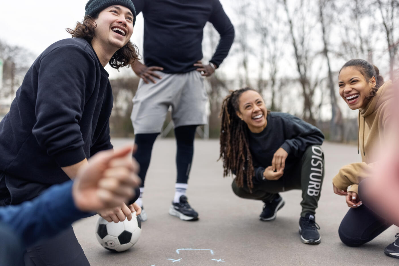 Soccer team smiling while planning the game strategy on the ground. Player in a huddle talking over game strategy on court.
