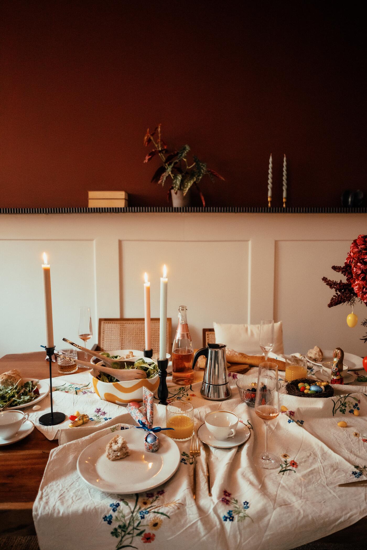 A beautifully decorated holiday dining table with candles, glassware, and seasonal décor set for a festive meal.