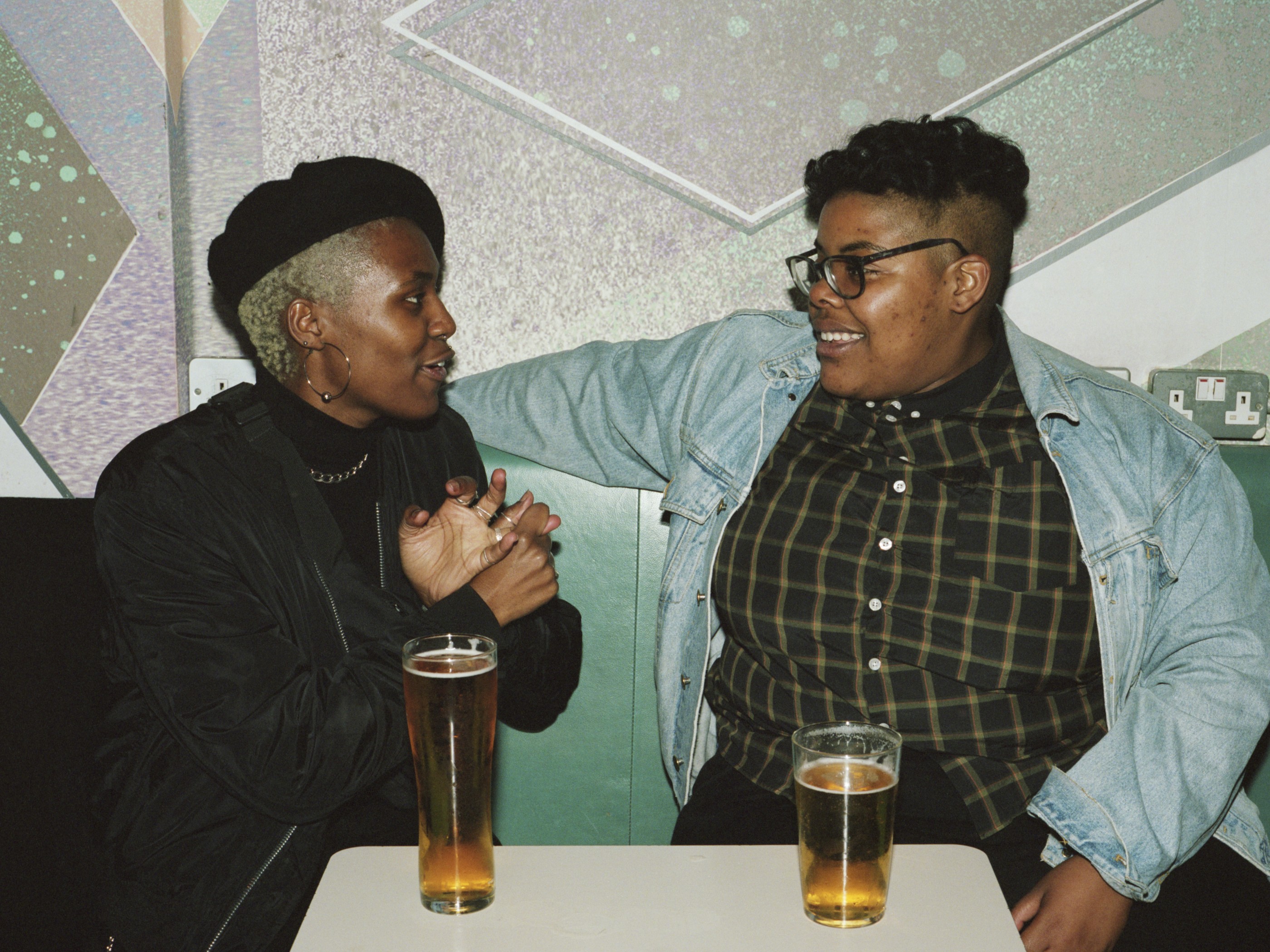 Two friends hanging out in a London LGBTQ+ nightclub - a bisexual woman and a non-binary queer person.