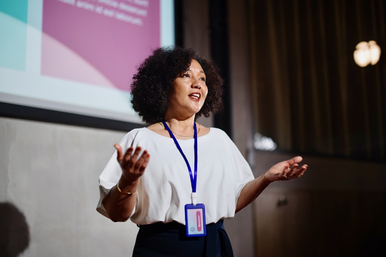 Black female professional giving presentation in a conference.