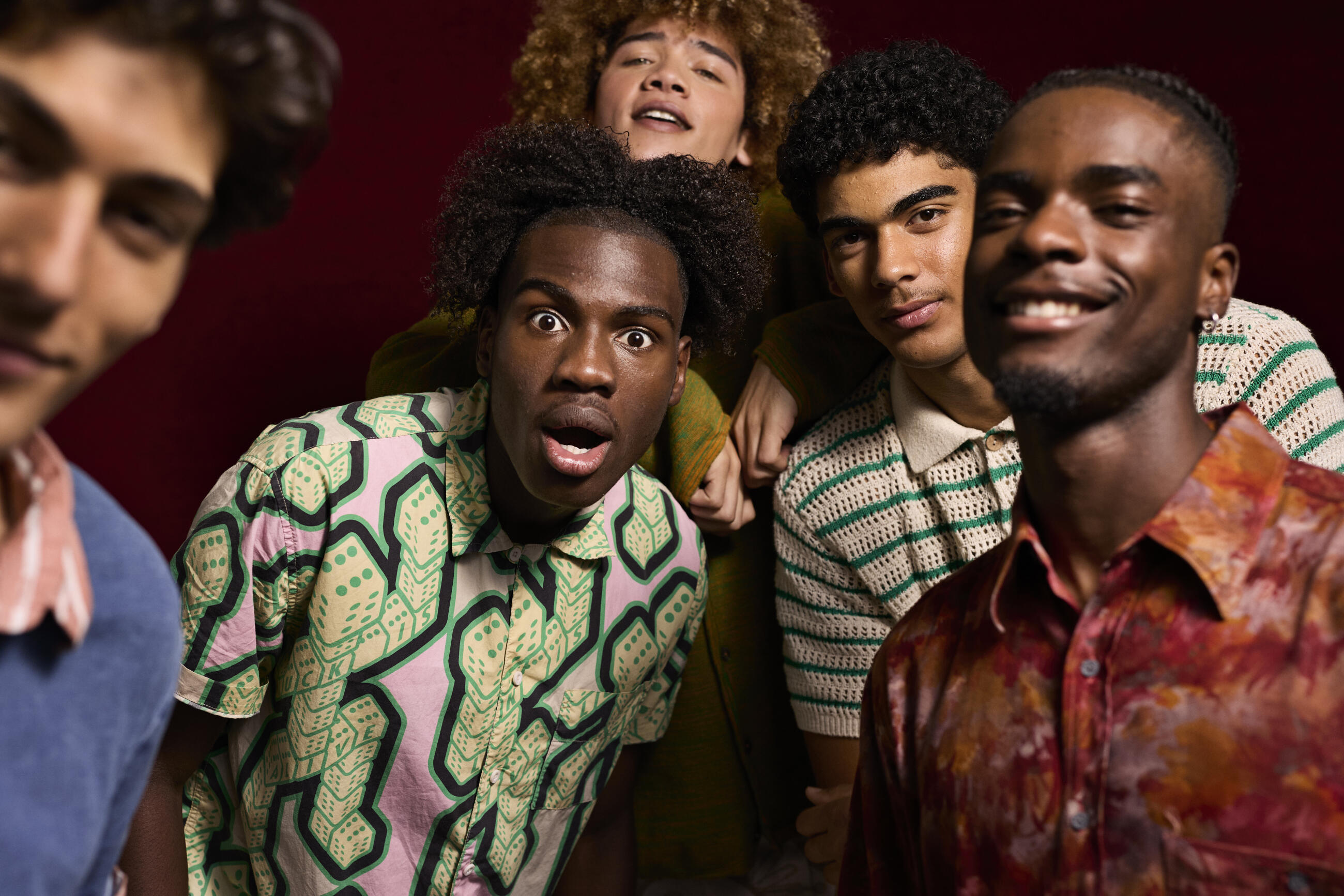 Portrait of man making face while standing with friends