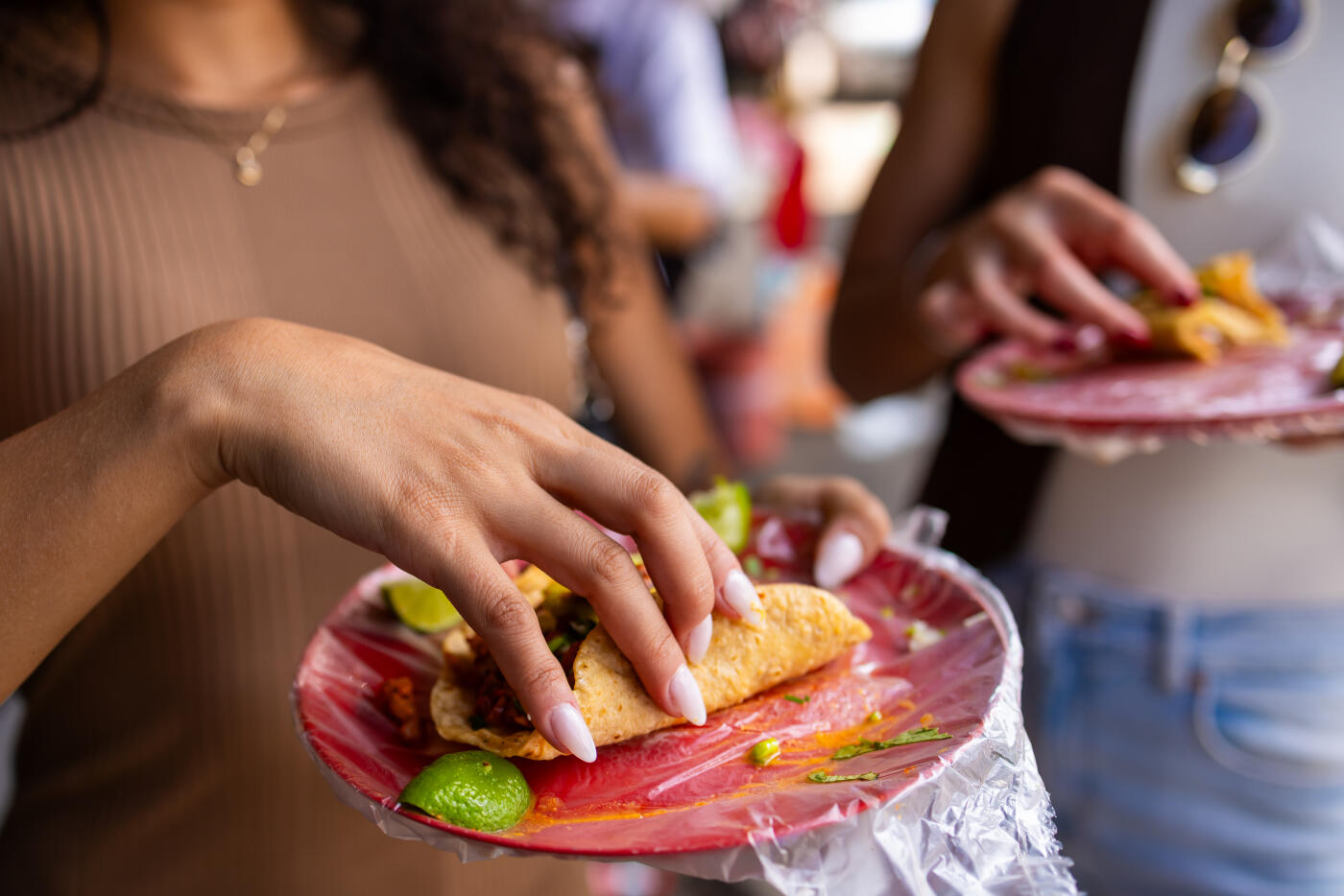 Two friends, getting to know Mexico, stop to eat tacos al pastor on the street.