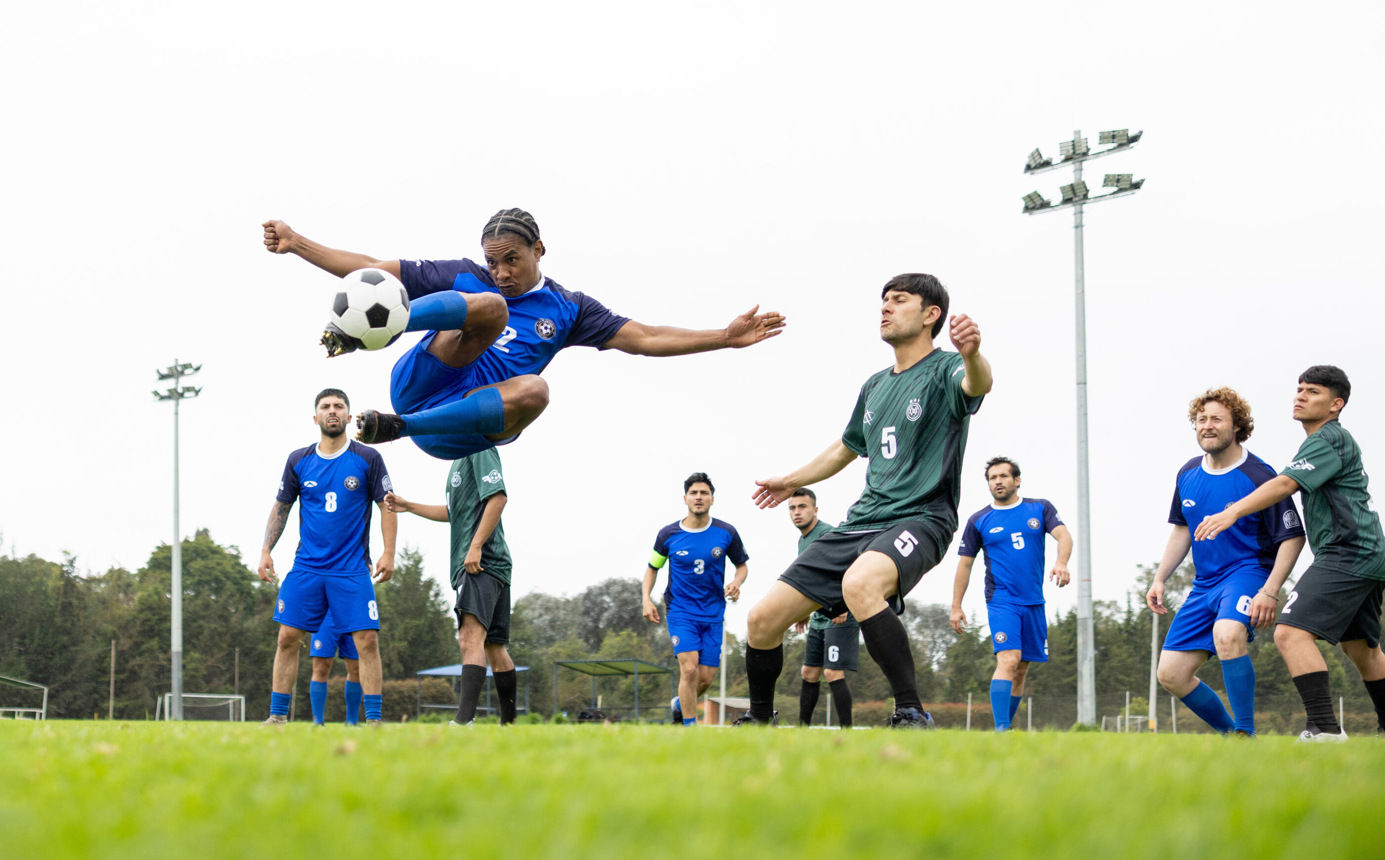 Latin American football player in the air taking a shot during a game - sports concept