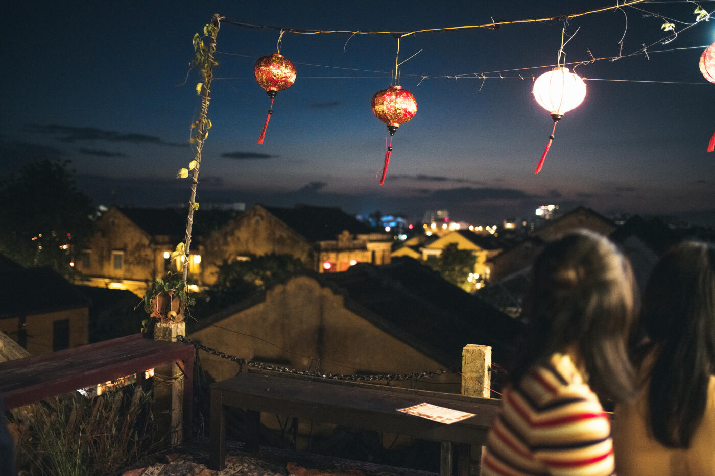 illuminated cityscape of Hoi An at night seen from roof top terrace with traditional lanterns