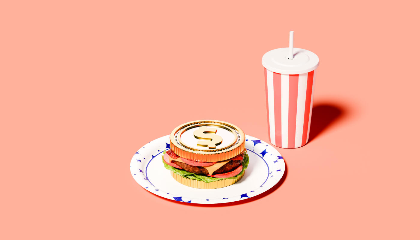 Conceptual image of a surreal fast food composition featuring a large golden dollar coin as the top bun of a burger resting on a blue-patterned paper plate next to a red-and-white striped takeaway drink cup with straw against a solid peach studio background, exploring form versus function through money and consumption.