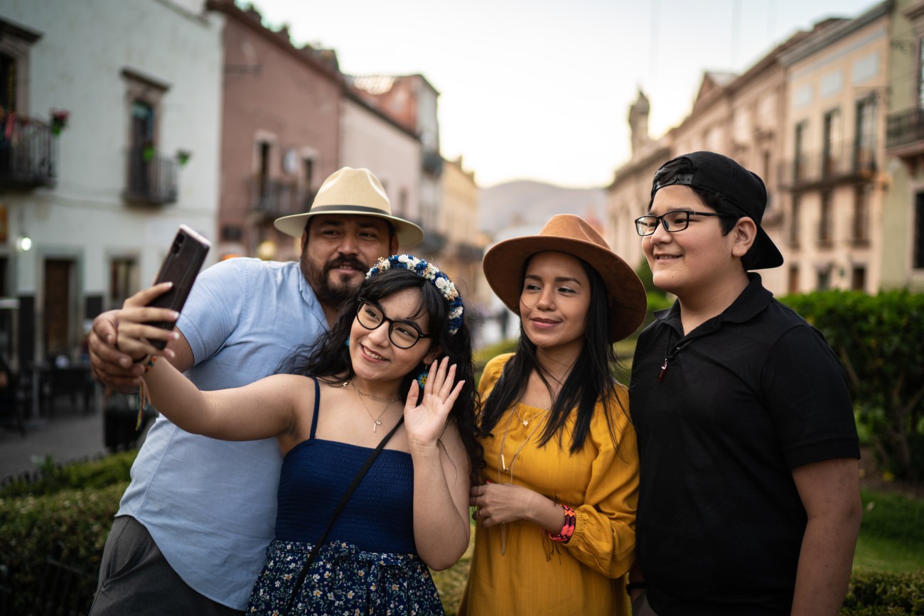 Family doing a video call or taking a selfie on mobile phone outdoors