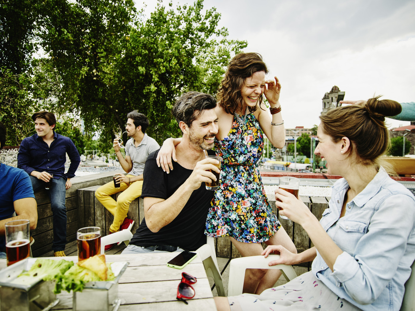 Laughing couple having drinks with friends
