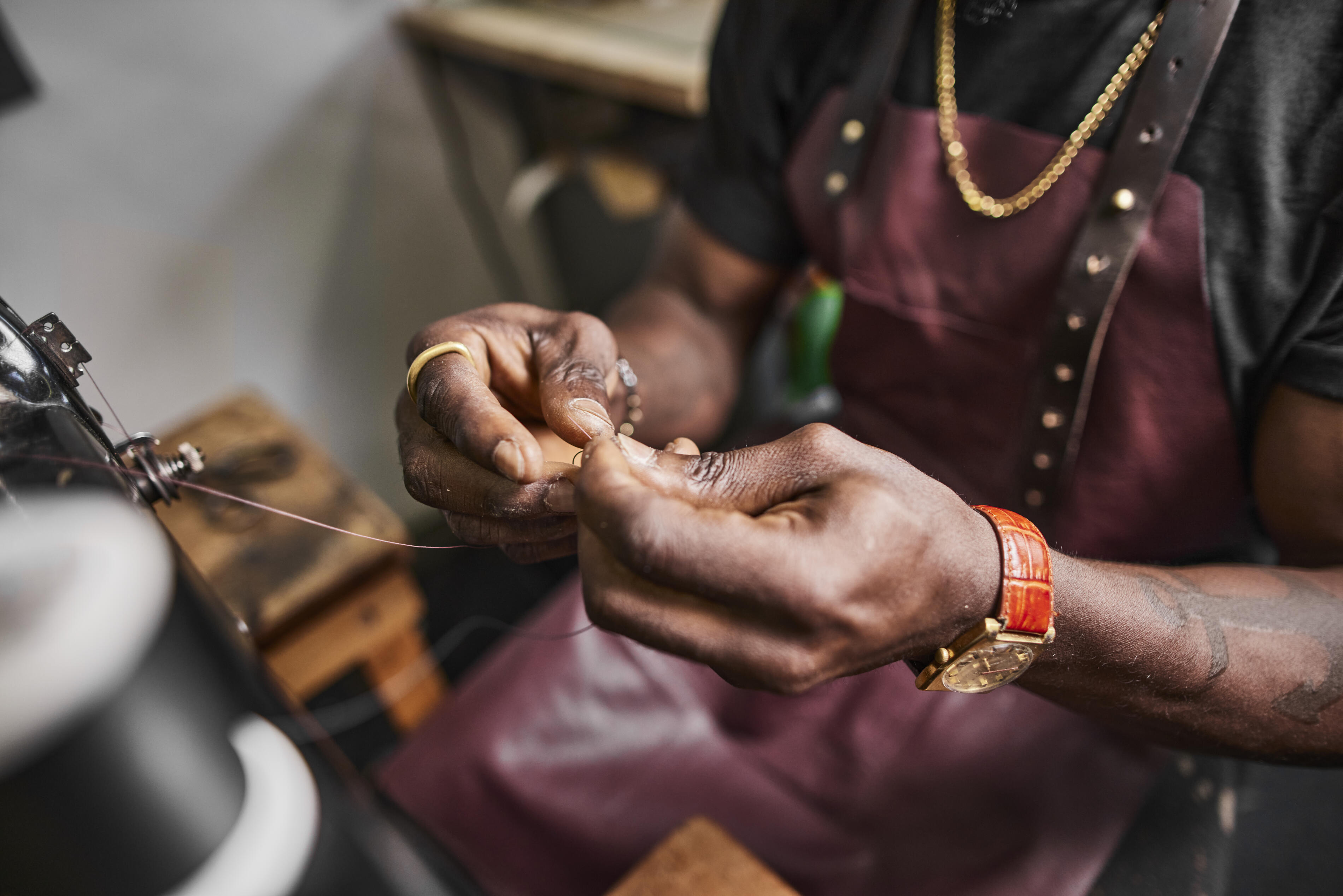 ミシンで糸を通す靴職人のクローズアップ