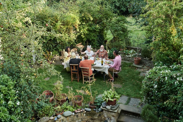 Friends talking and dining outside on a warm summers day.
