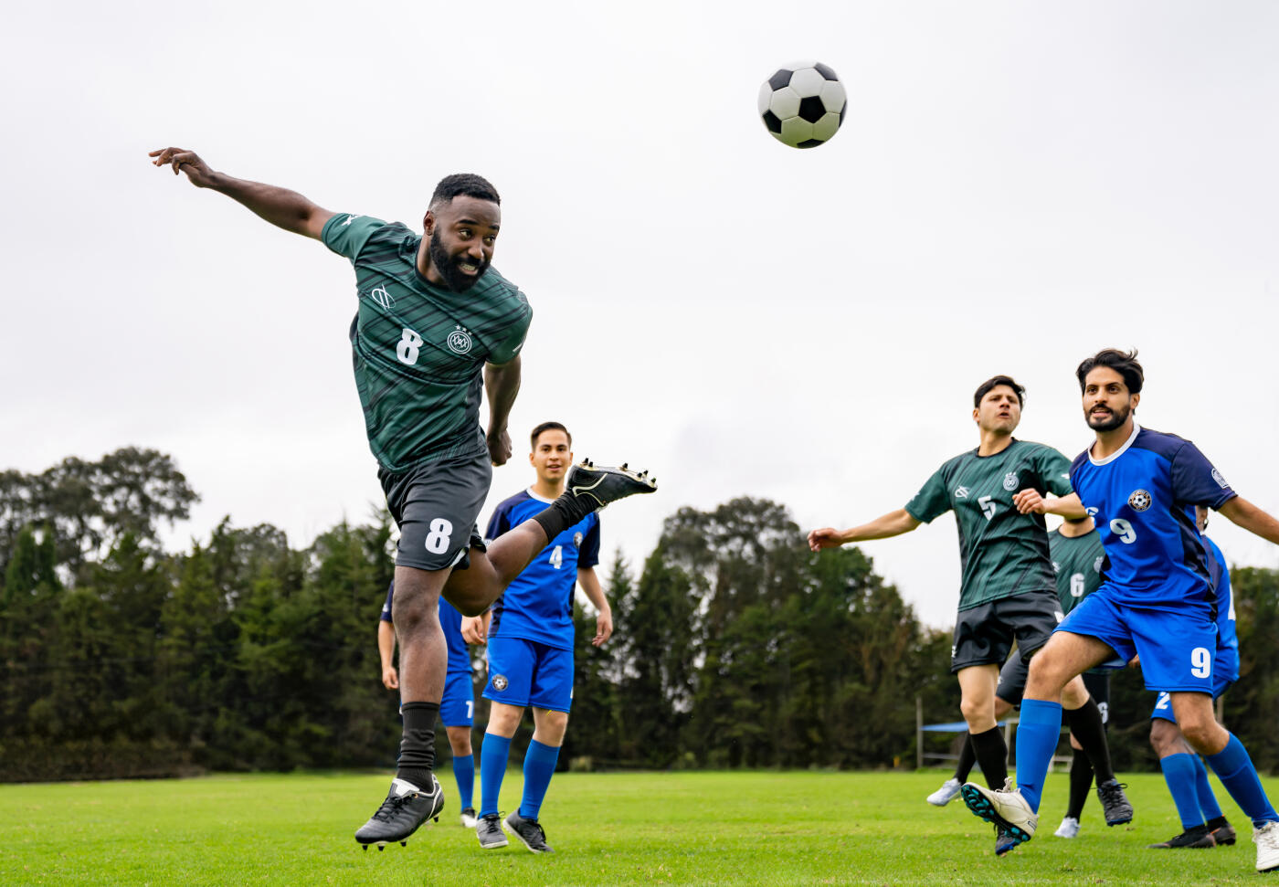 Latin American soccer player in the air heading a ball during a game - sports concept