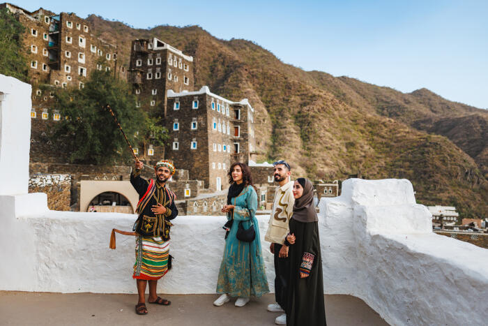 Enthusiastic Saudi Tour Guide Explaining Rijal Almaa History
