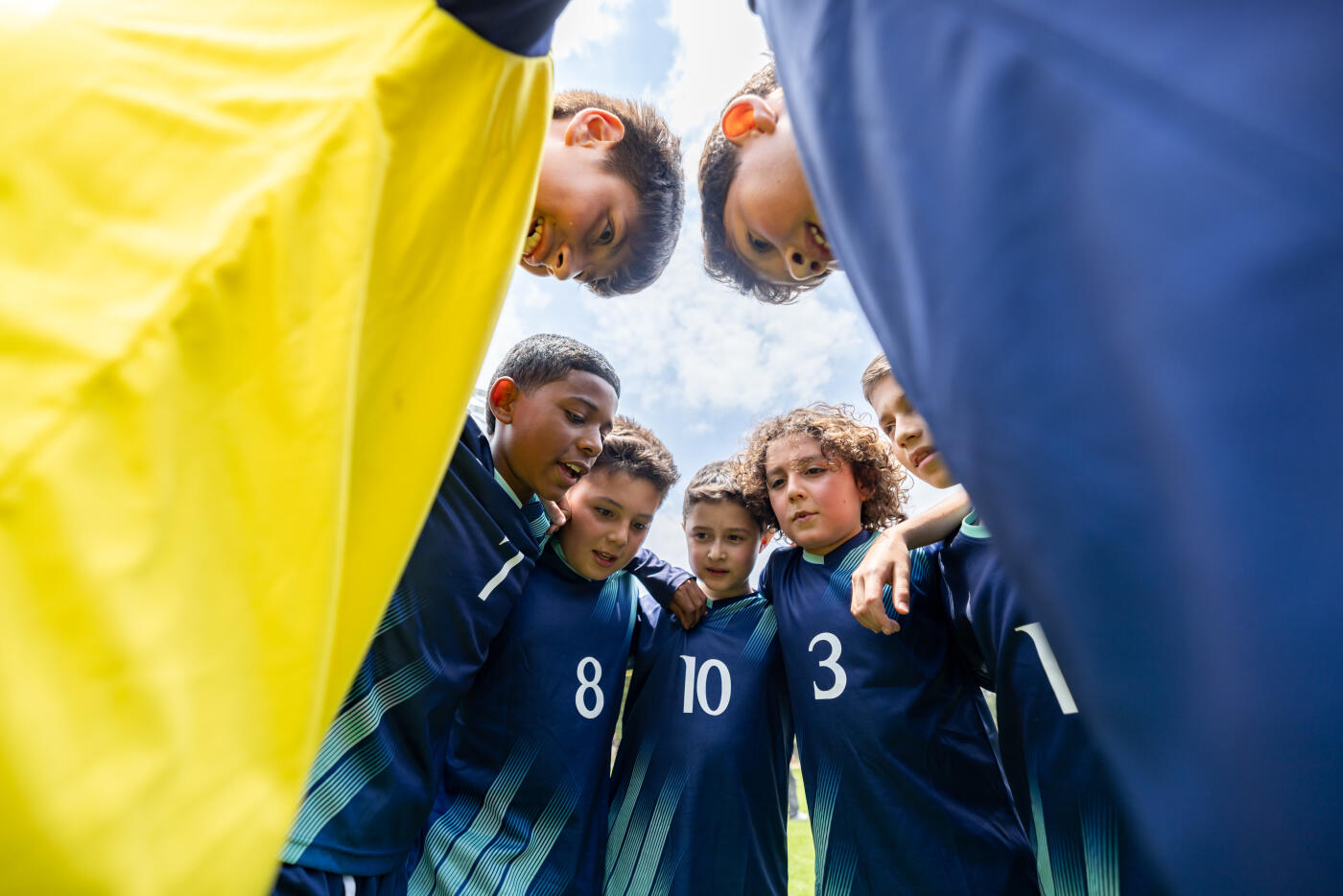 Latin American kids soccer team huddling before a game for motivation - sports concepts
