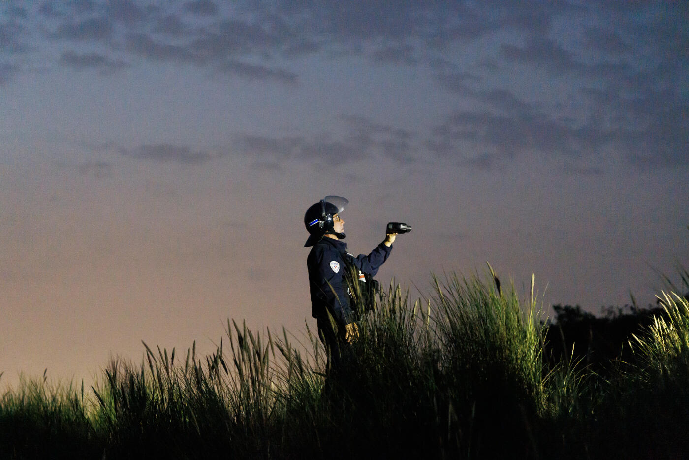GRAVELINES, FRANCE - AUGUST 14: French police officers use thermal imaging equipment to check the dunes for migrants on August 14, 2025 in Gravelines, France. More than 50000 small boat migrants have now crossed the English Channel illegally since Labour came to power last July. Last week the UK and France began implementing the so-called 'one-in, one-out' treaty, which was agreed during French President Emmanuel Macron's state visit last month, in an effort to curb illegal migration across the English Channel. Under the pilot scheme, a proportion of undocumented people arriving to the UK in small boats will be returned to France, in exchange for the same number of legitimate asylum seekers who may have family ties in the UK. (Photo by Dan Kitwood/Getty Images)