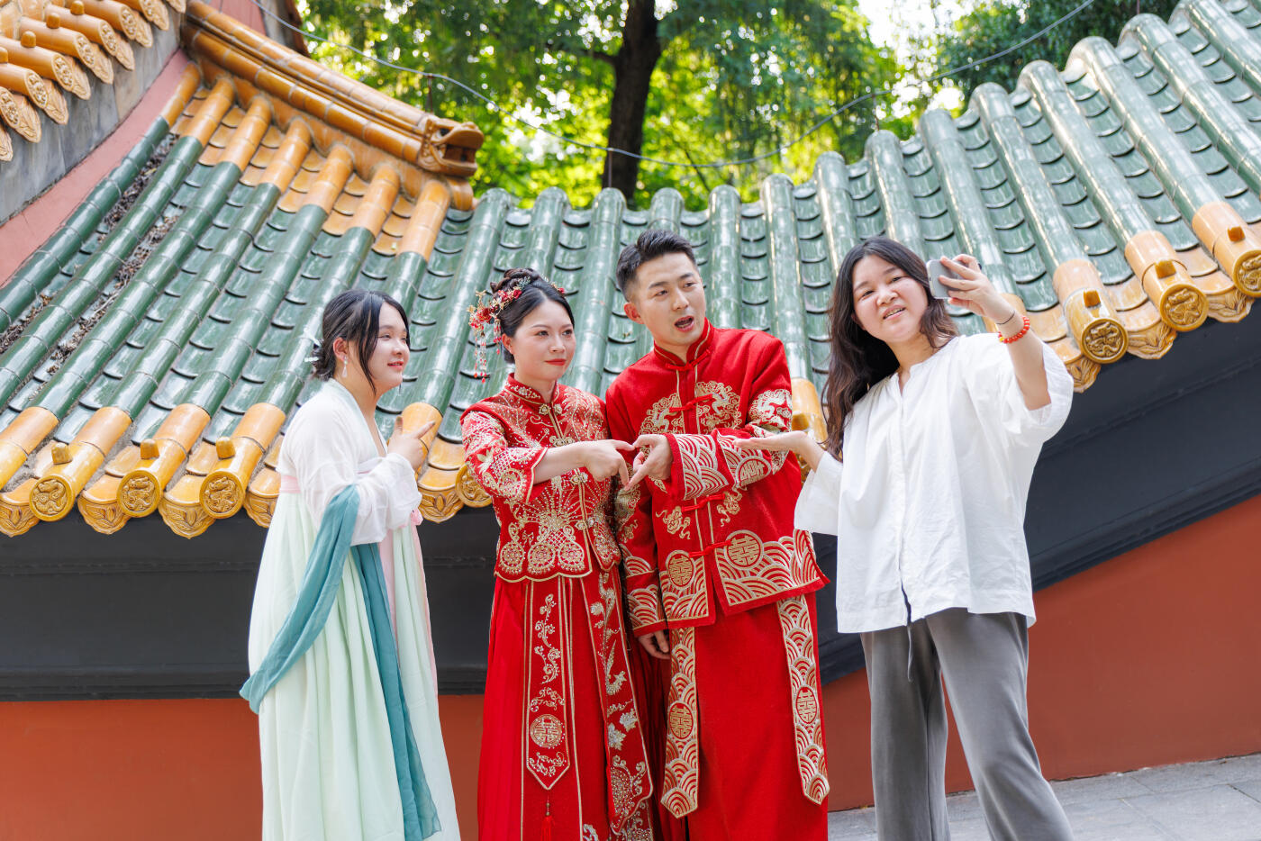 A Chinese newlywed couple in their 30s, wearing Hanfu costumes, poses with friends on a traditional Chinese street on their wedding day