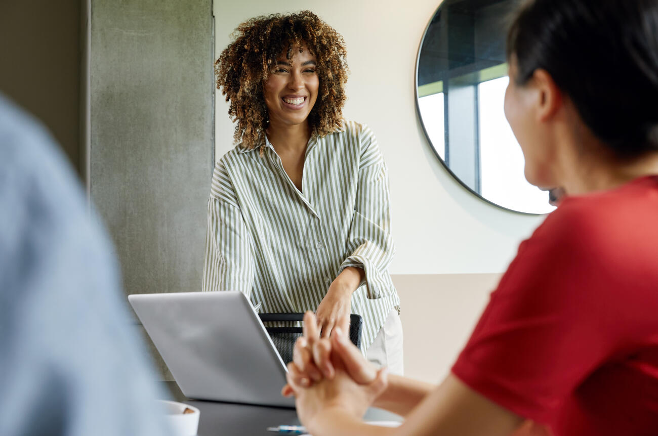 Junge Frau bespricht Projekt mit Kolleginnen und Kollegen im Büro