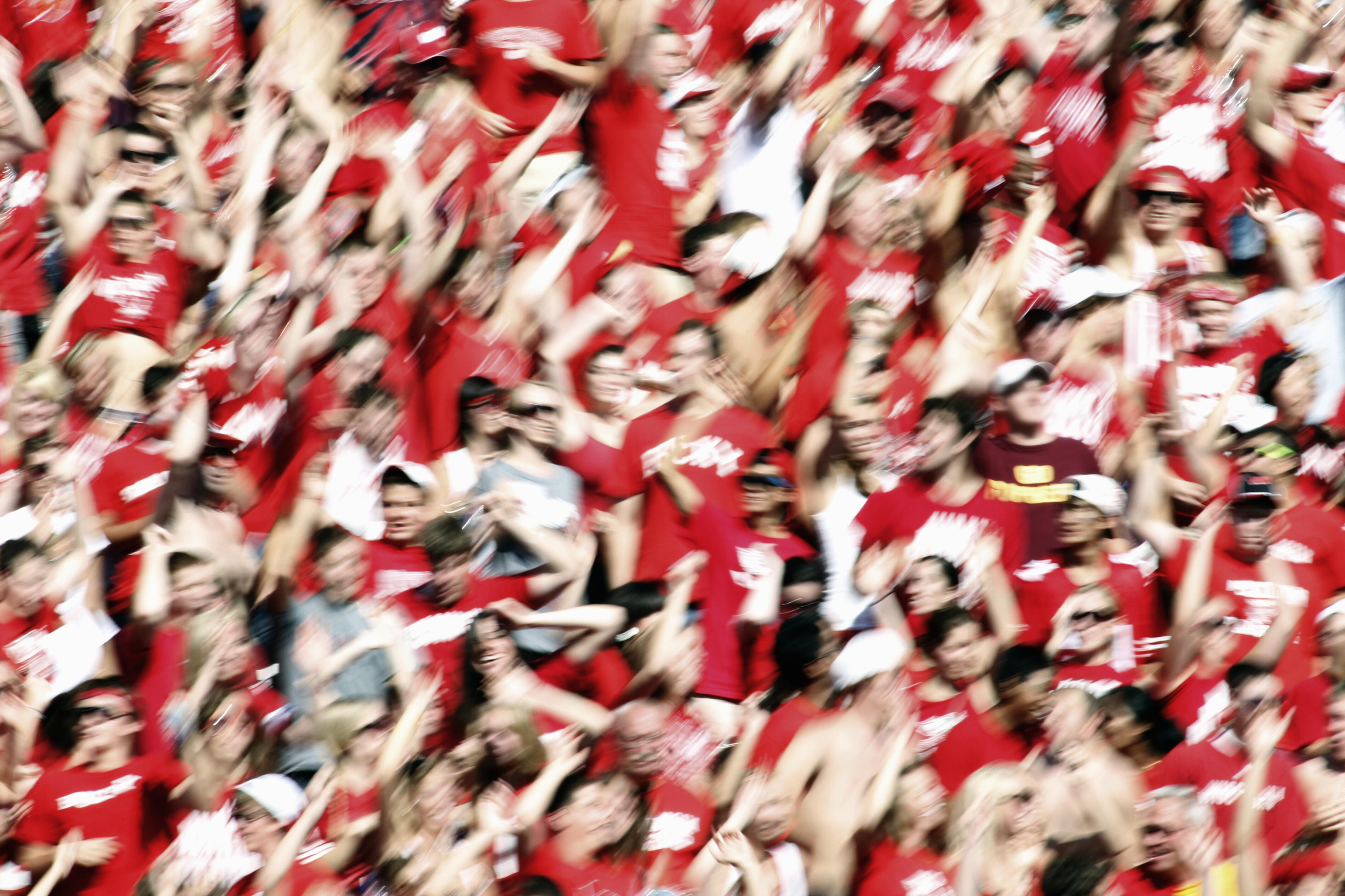 Fans at a football game jump and cheer.