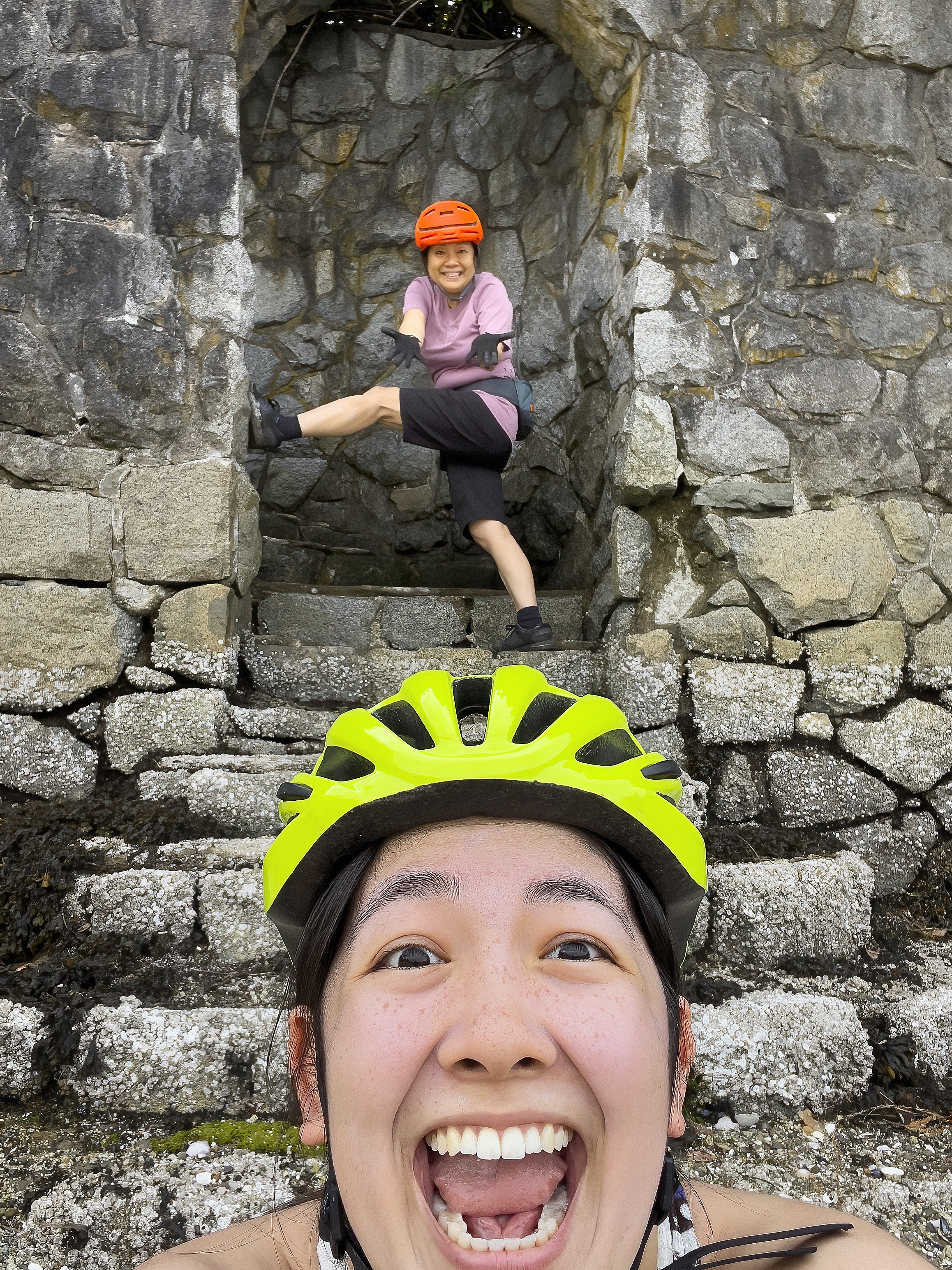 Aziatische oudere moeder, multiraciale dochter fietsers poseren voor de lol in een boog