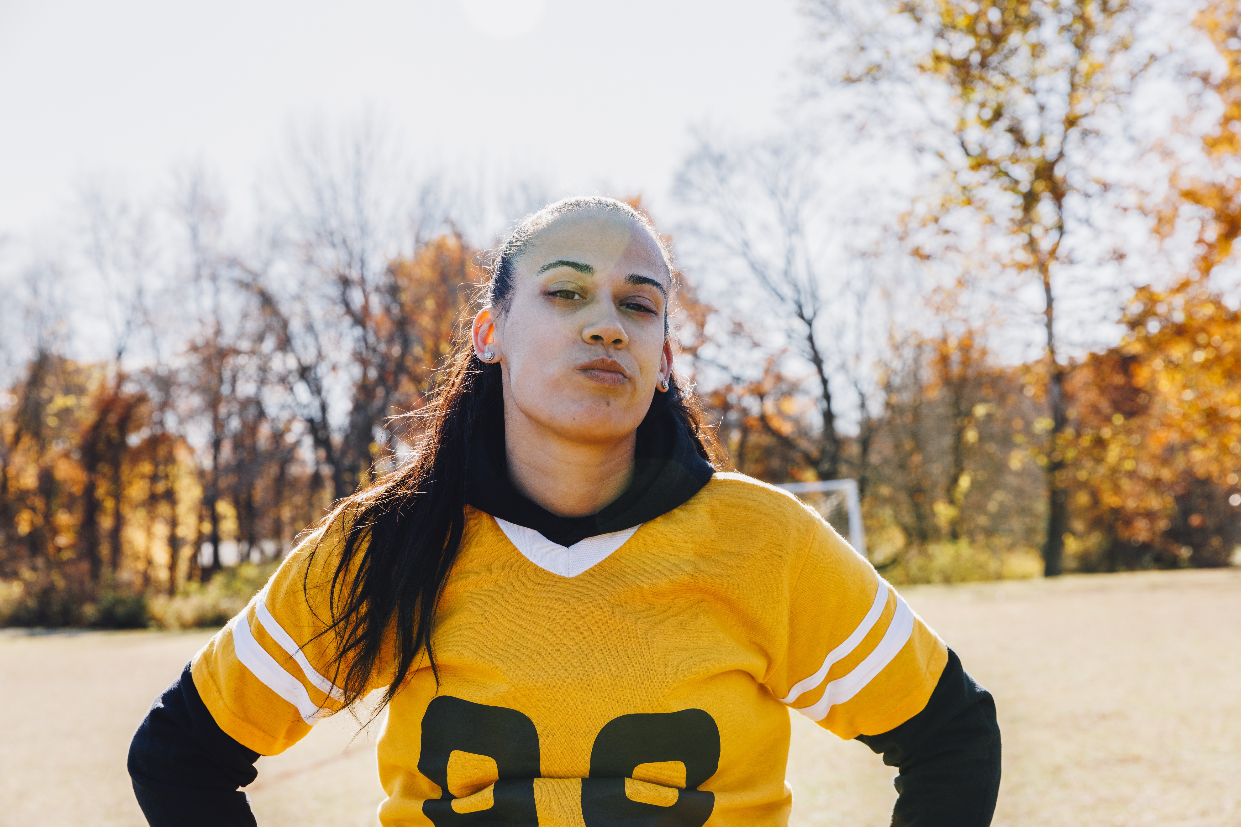 Portrait of confident female athlete standing on football field