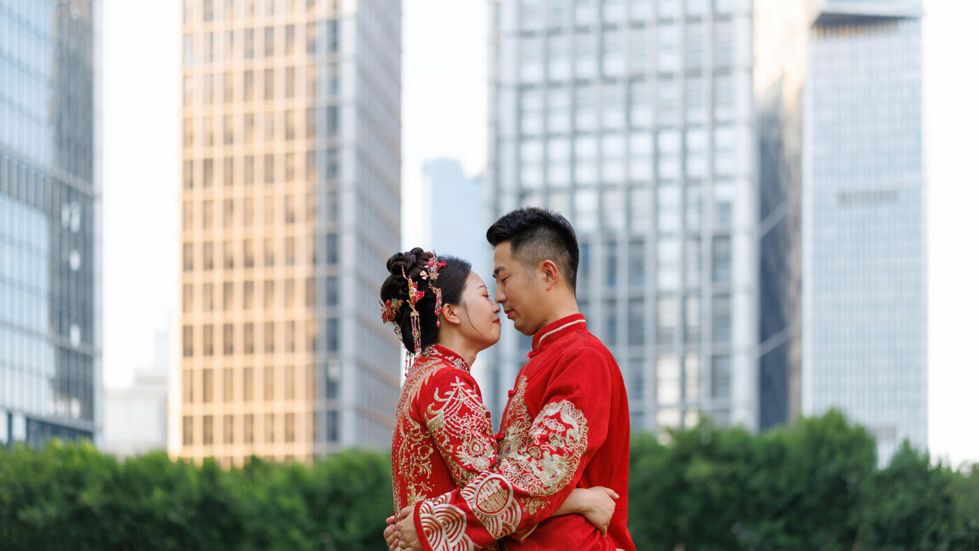 A Chinese newlywed couple in their 30s, wearing Hanfu costumes, hug each other in a modern city on their wedding day, traditional costumes and modern city concept