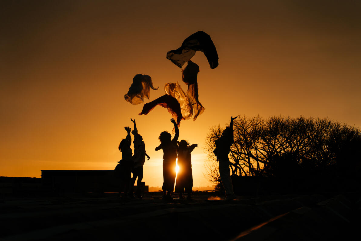 Conceptual images of dancers dancing with fabrics at sunset.