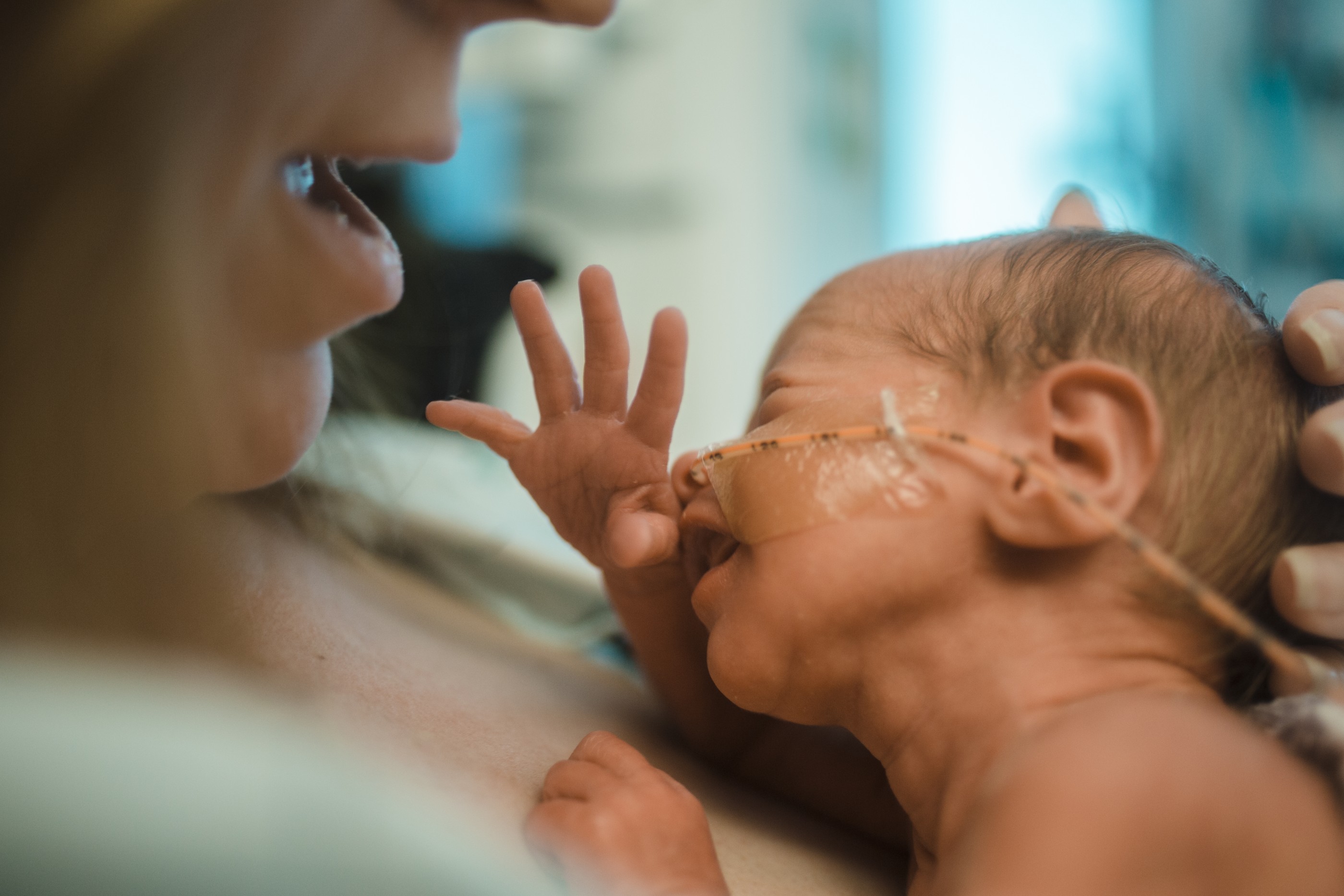 A mother tenderly holds her newborn baby at the hospital.