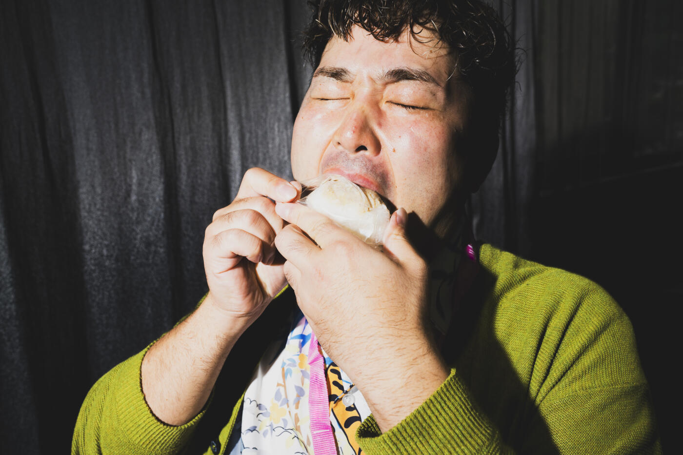 Close-up of Adult male biting into food with eyes closed