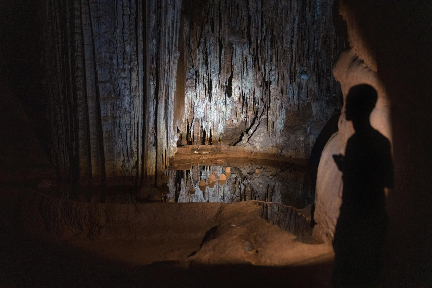 SOCOTRA ISLAND, YEMEN - OCTOBER 11: A guide illuminates a speleothem with a flashlight in Hoq Cave on October 11, 2025 in Socotra, Yemen. Socotra island, sometimes referred to as the "Galapagos Islands" of the Indian Ocean, lies about 150 miles off the coast of the Horn of Africa and is home to 825 plant species, more than a third of which are only found here. Among them are the otherworldly dragon's blood tree, bottle trees and 11 species of frankincense, 4 of which were classified as critically endangered in March of this year. The intensifying tropical cyclones in this part of the Indian Ocean, fuelled by climate change, has put the island's unique ecosystem at risk. Meanwhile, Yemen's civil war - as well as the region-destabilizing attacks on commercial vessels in the Red Sea - have complicated conservation efforts. (Photo by Carl Court/Getty Images)