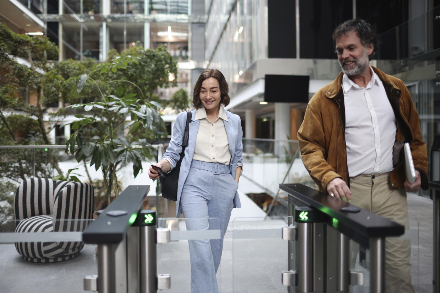 Two colleagues, a man and a woman discussing as they live their workplace