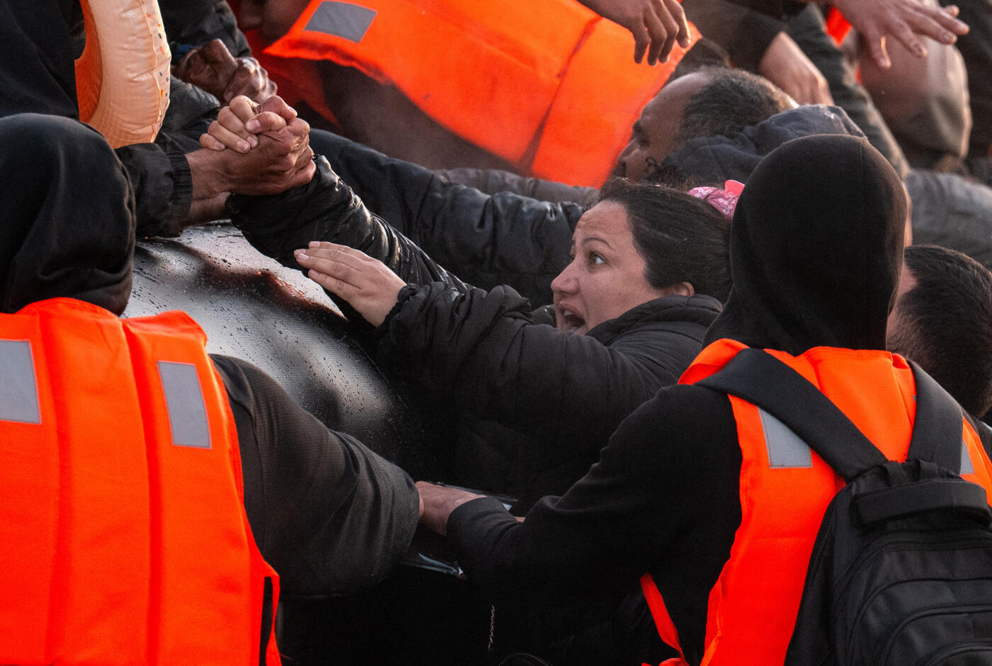 GRAVELINES, FRANCE - MAY 31: A woman reacts as she is lifted into a migrant dinghy on May 31, 2025 in Gravelines, France. The numbers of migrants crossing the English Channel in small boats is up roughly 40% on last year. It was reported in April that the UK and France are holding negotiations over a potential deal to return irregular migrants who cross the English Channel in small boats. The pilot scheme would see the UK send a limited number of people who have crossed illegally sent back to France, in exchange for accepting some people who have a case for family reunification and right to be in the UK. (Photo by Carl Court/Getty Images)