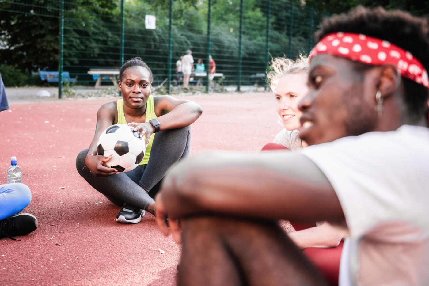 young international sports people sitting in circle on hard court in Berlin