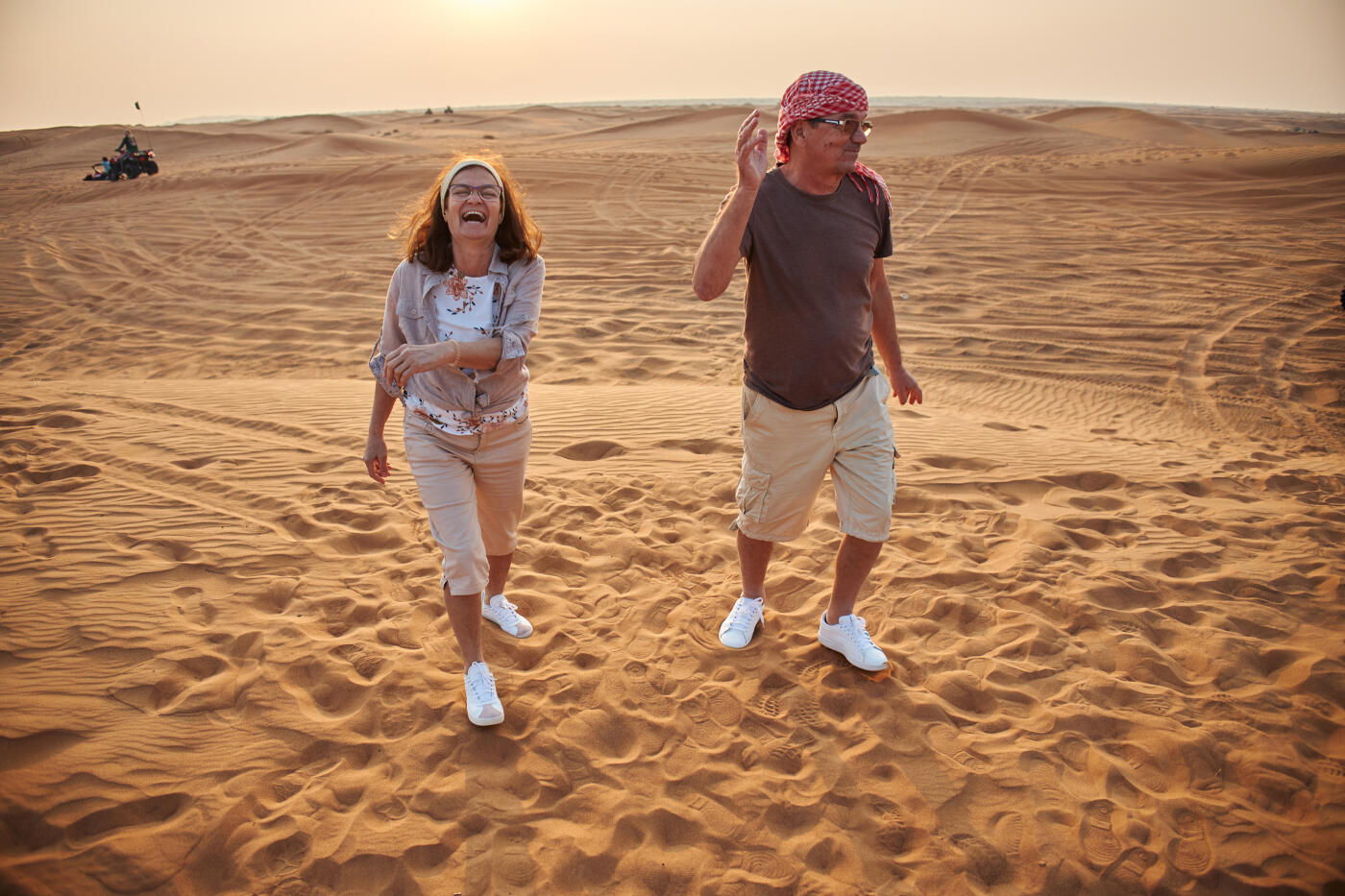 Beautiful active seniors in Dubai desert. Vacation mood.