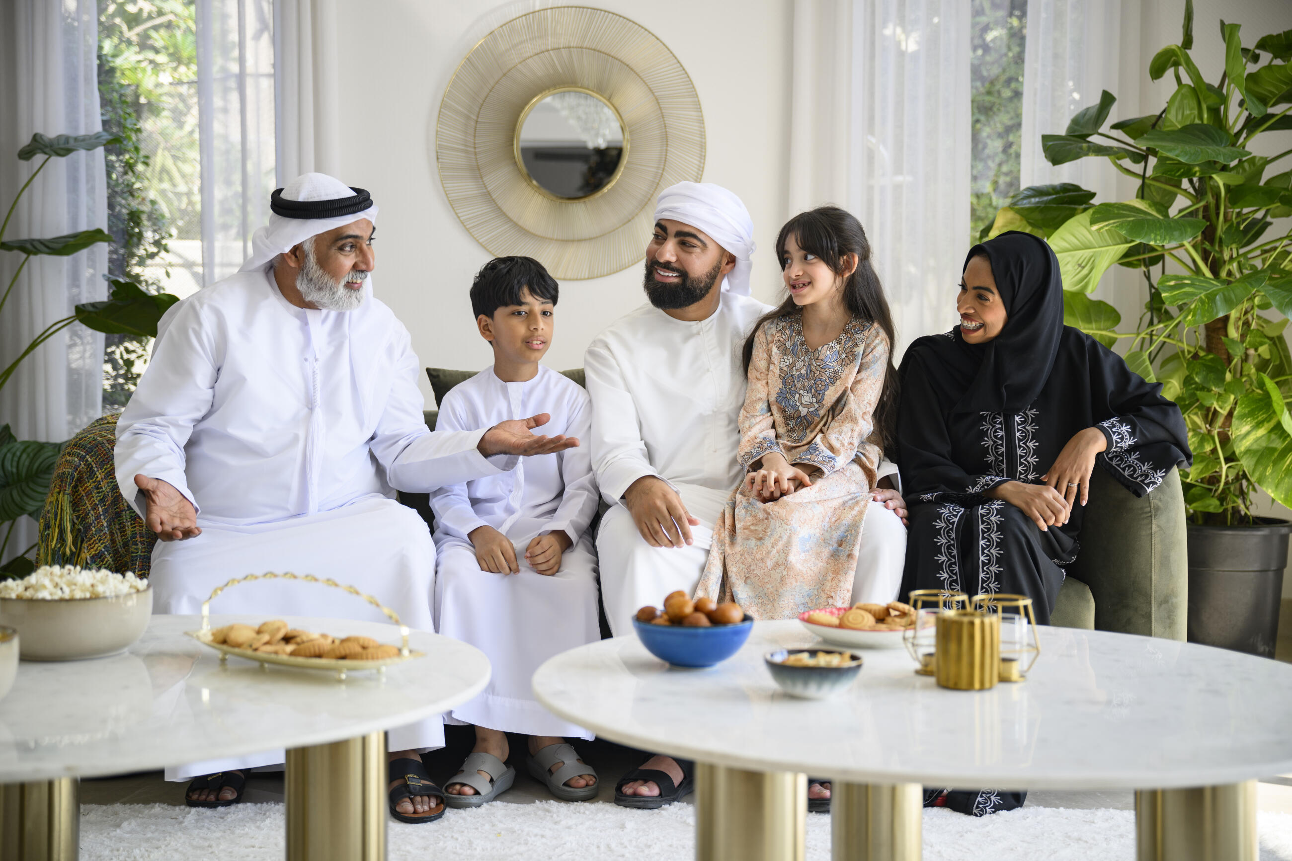 Candid portrait of three generation Middle Eastern family talking and enjoying celebrating Eid-Ul-Fitr together