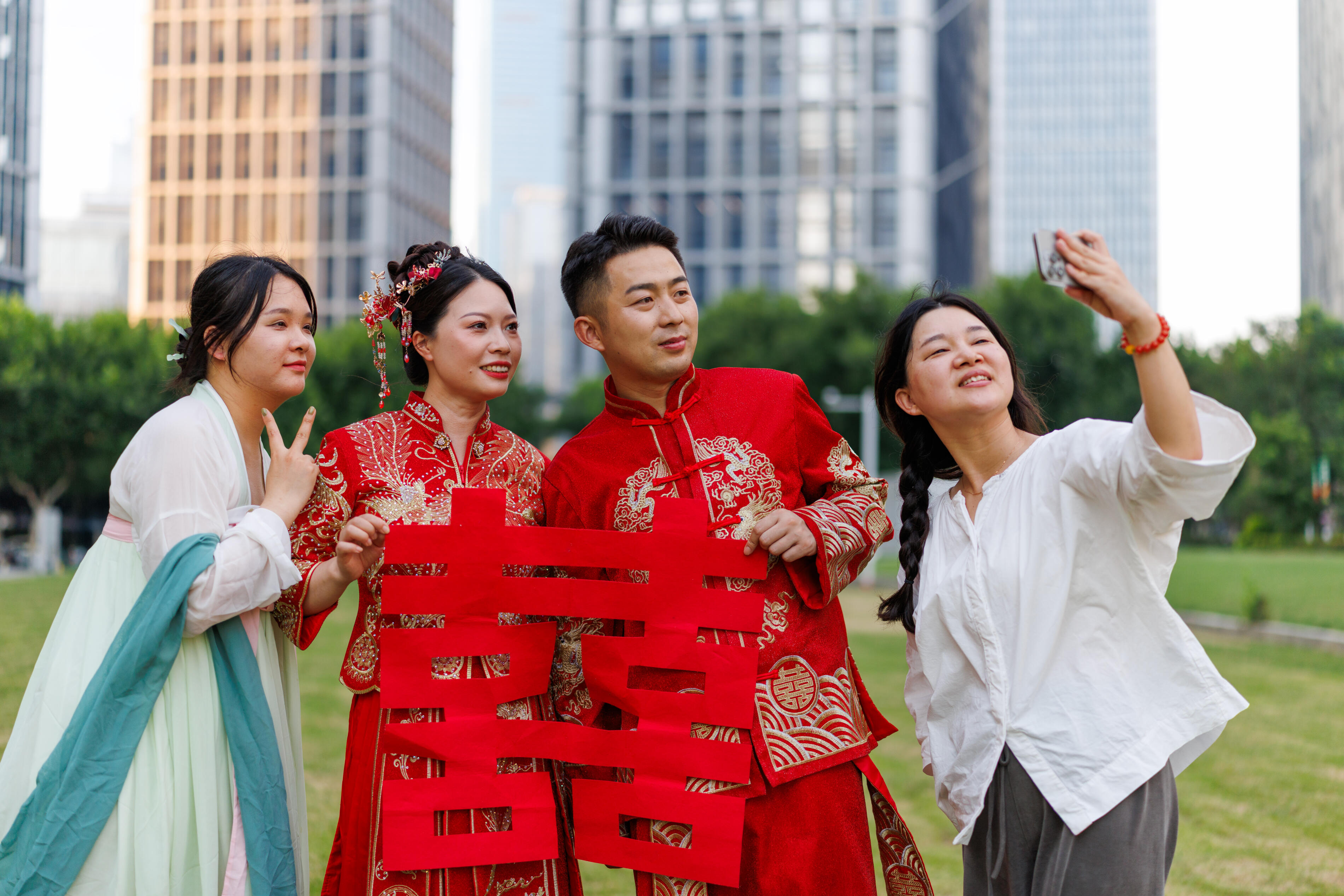 A Chinese newlywed couple in their 30s, wearing Hanfu costumes, taking photos with friends on their wedding day in a modern city, traditional costumes and modern city concept