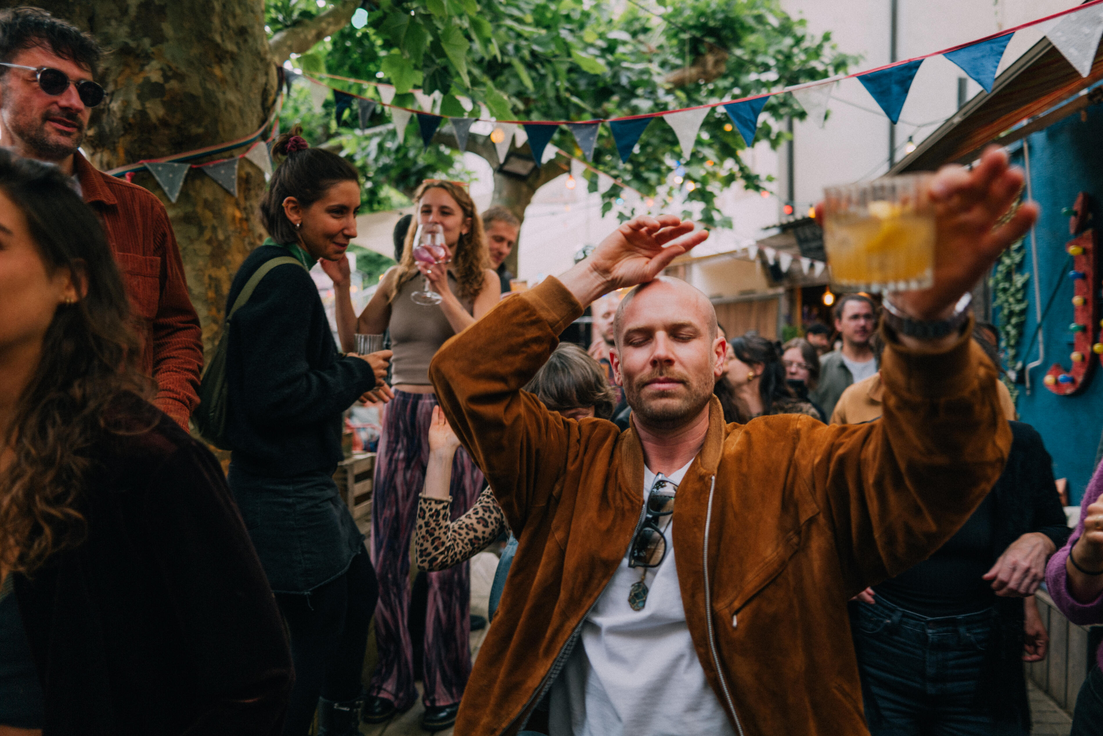 Outdoor Party With People Dancing, Enjoying Drinks and Music in Festival Atmosphere